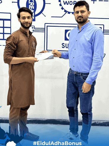 Team Lead Farhan Ghaffar awarding a cash prize to an employee at a CodeAutomation event, showcasing the company's recognition culture.