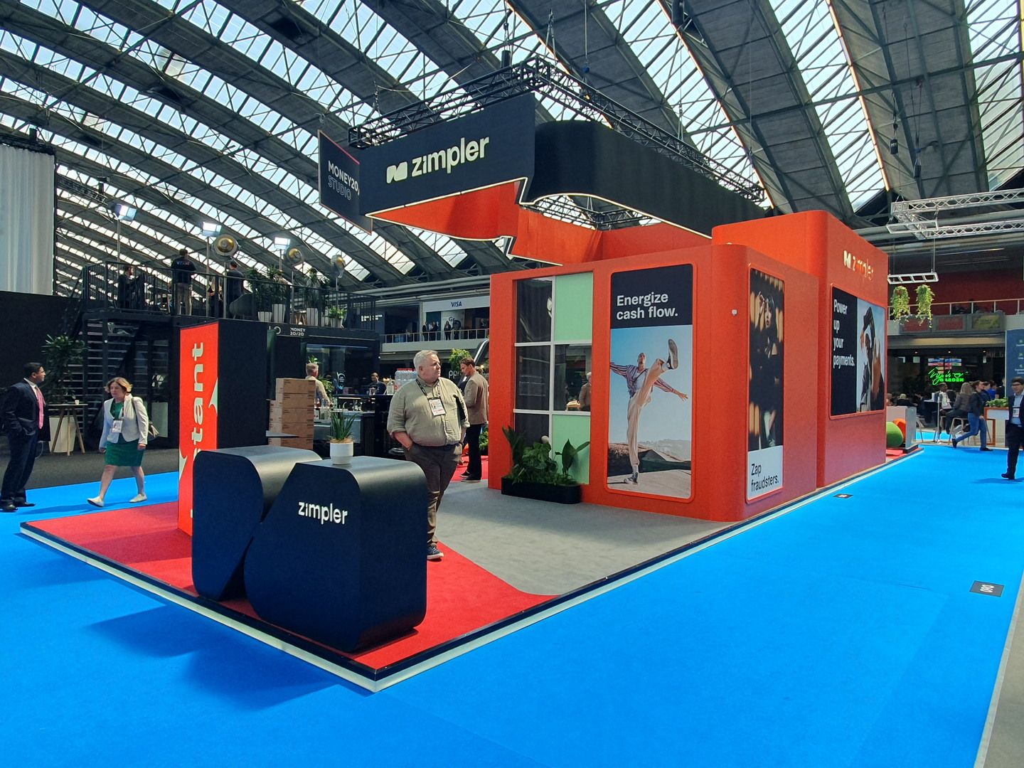 Zimpler stand during Money20/20 Europe 2023 with visitors, hospitality area and prominent branding