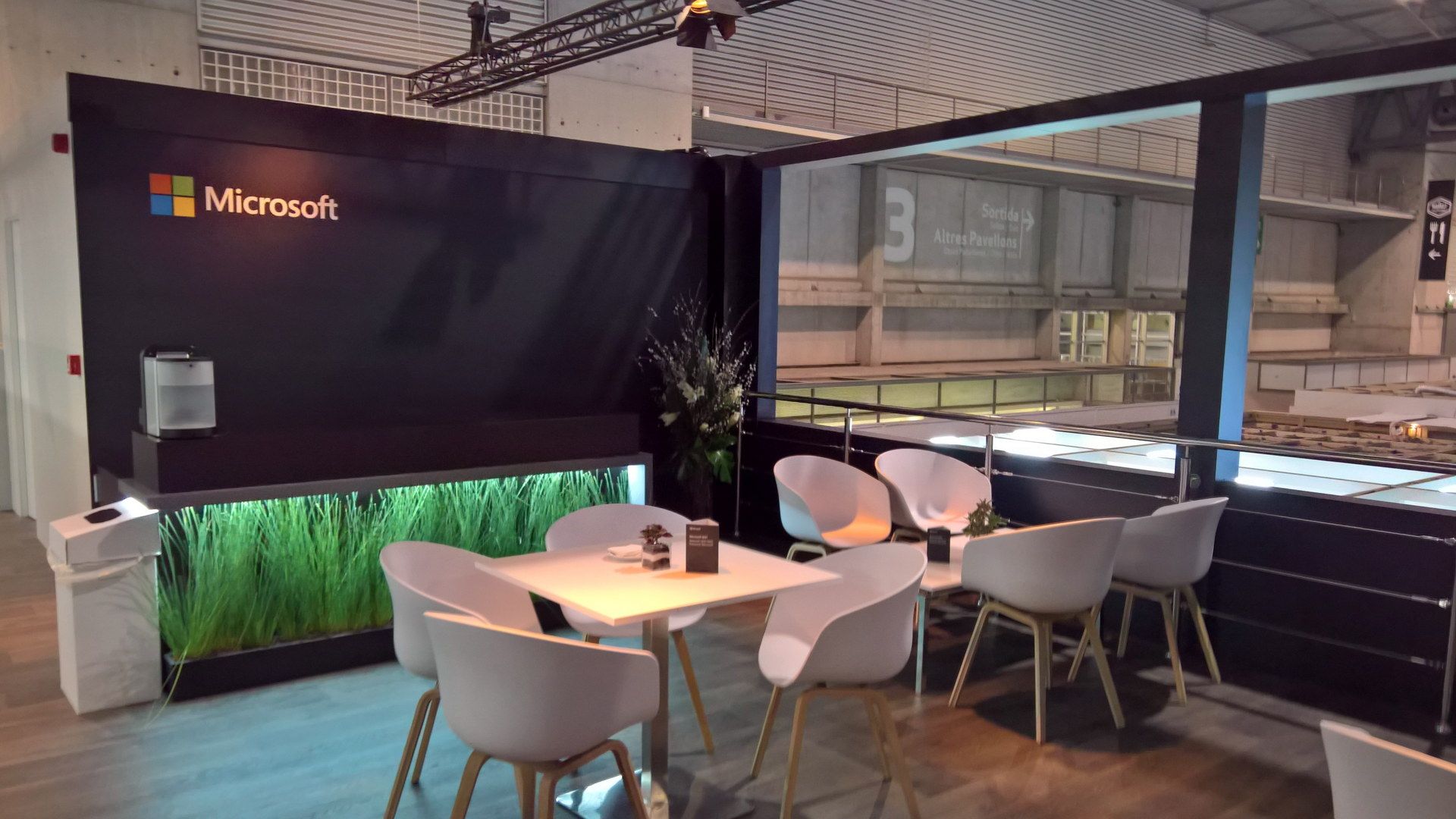 Mesa de reunión con pantalla y asientos blancos — Microsoft — MWC Barcelona