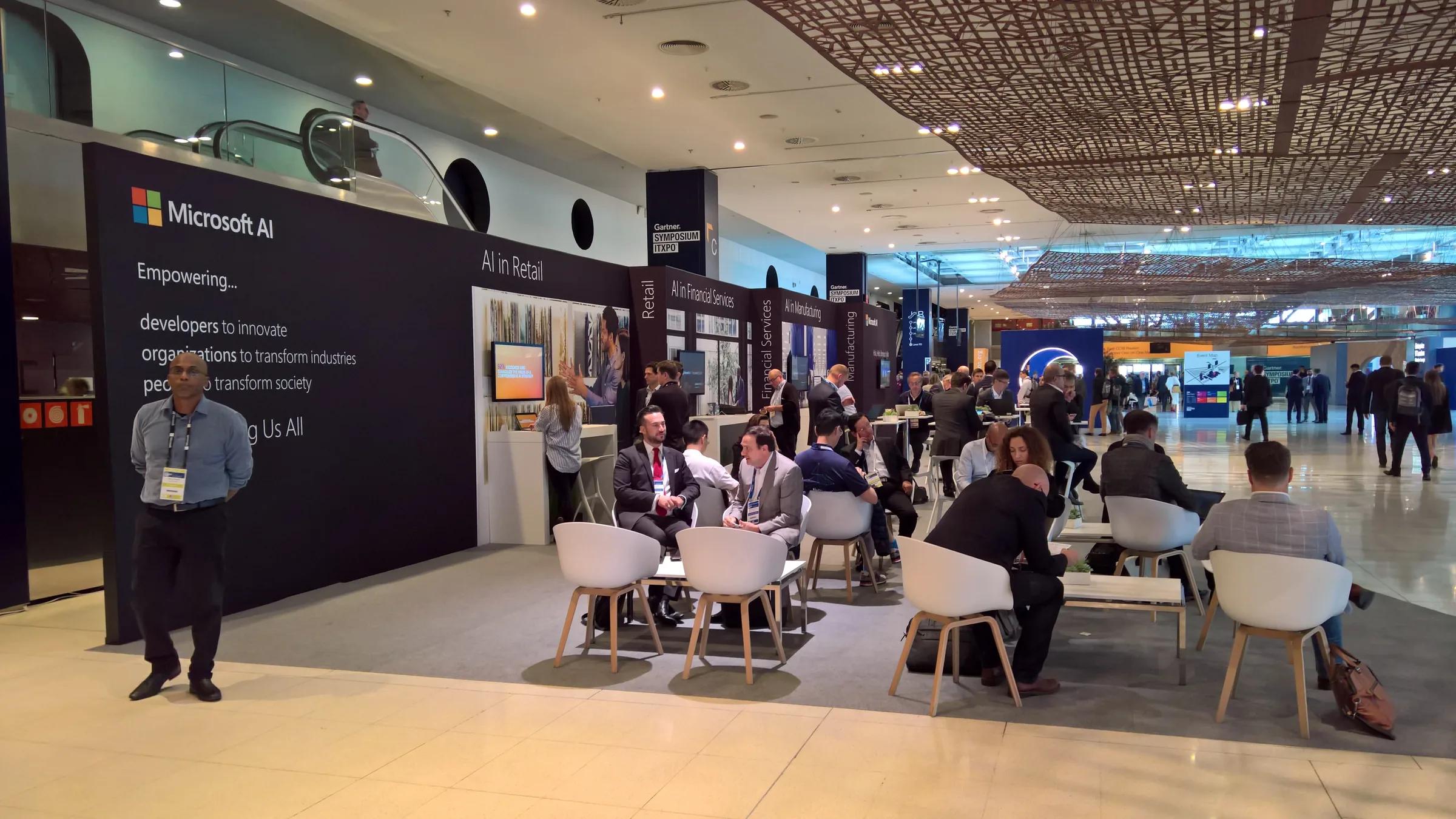 Área abierta de reuniones con mesas y visitantes · ITXPO 2018