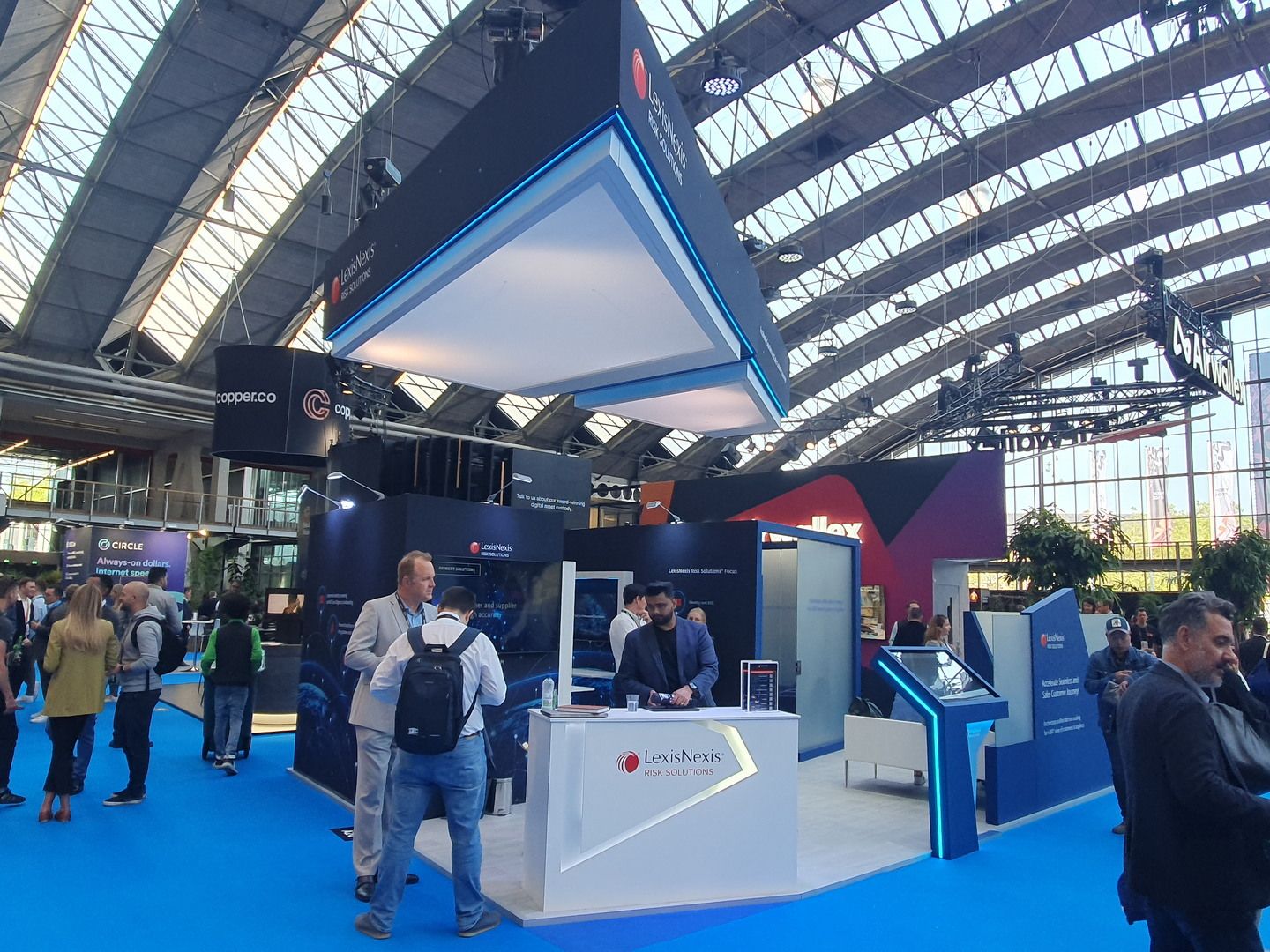 Vista del stand de LexisNexis en RAI Amsterdam con módulos interactivos, pantallas e iluminación azul