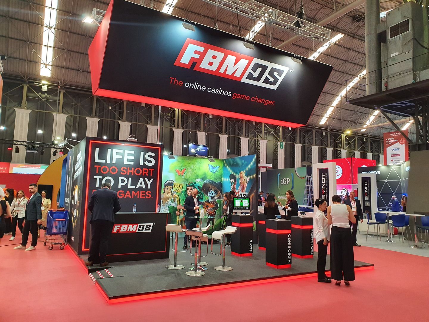 Vista general del stand de FBM Digital Systems en SBC Summit Barcelona 2023, con rótulo suspendido negro y rojo