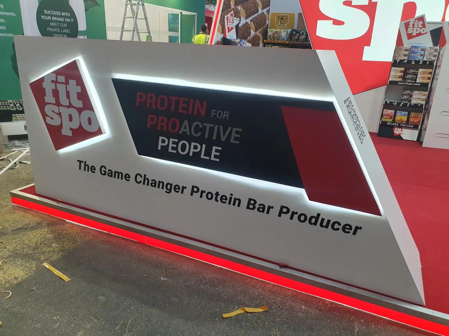 Detail of the FitSpo counter with white lighting around the graphics and red lighting at the base during installation.