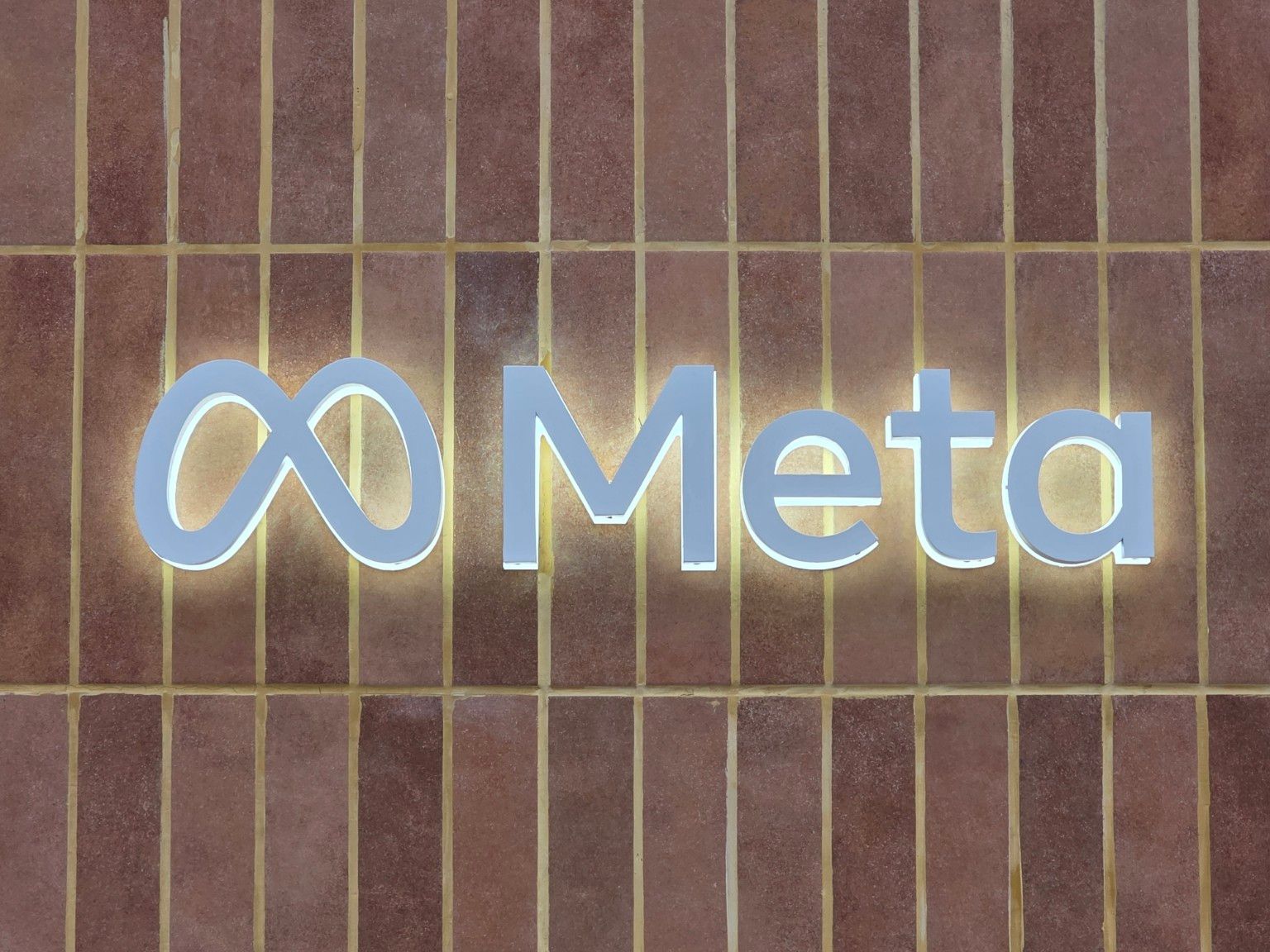 Backlit Meta logo on the facade’s vertical ceramic tiles
