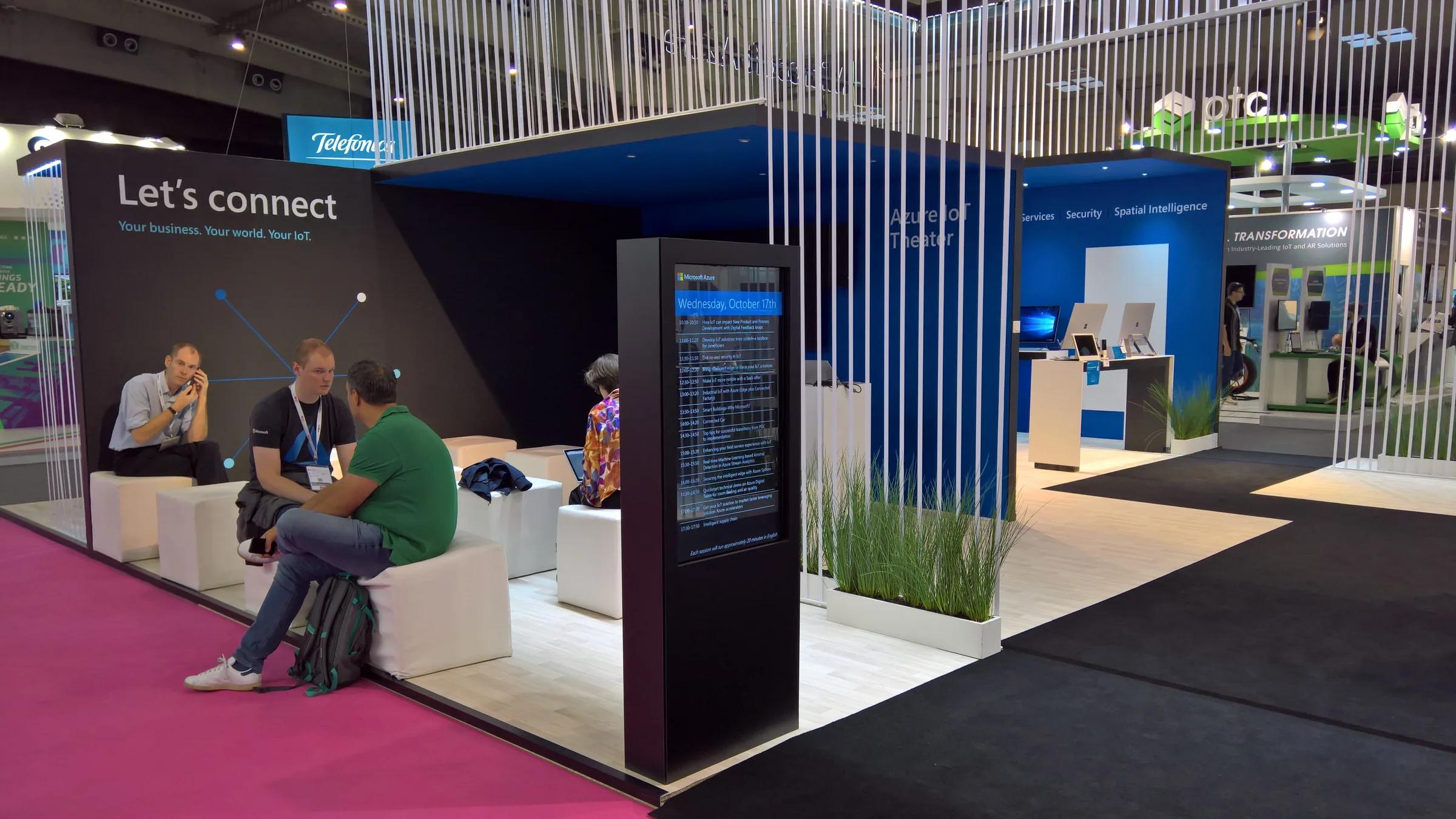 Zona de encuentro con asientos blancos y vegetación · IoT 2018