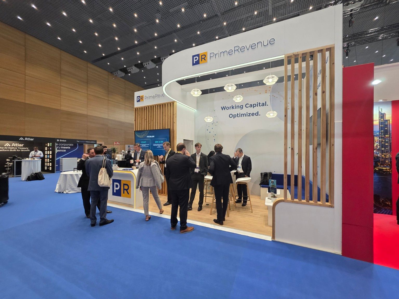 Open view of the PrimeRevenue stand, with pendant lights and meeting areas at EuroFinance 2026
