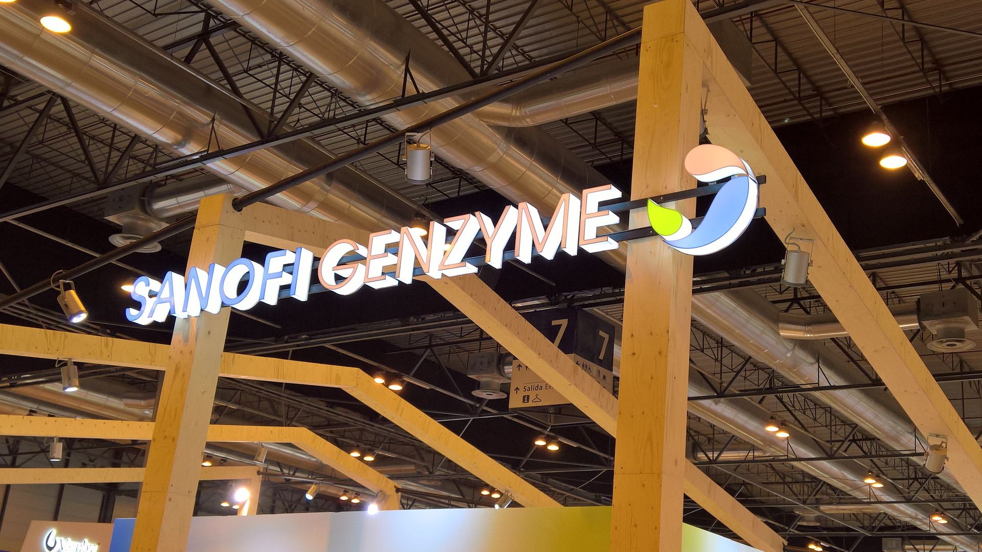 Joinery detail and illuminated brand lettering — Sanofi Genzyme · ESMO