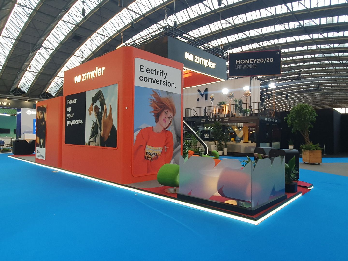 Detail of the Zimpler stand at Money20/20 Amsterdam with perimeter lighting and informal meeting areas