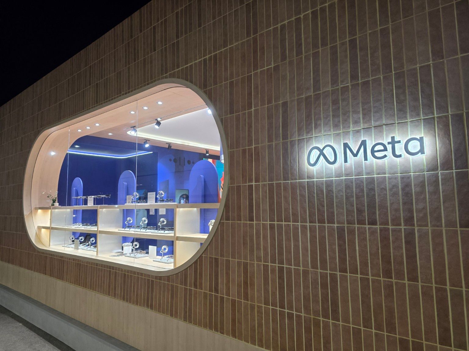 Detail of the eyewear display window and backlit logo on Meta’s ceramic facade