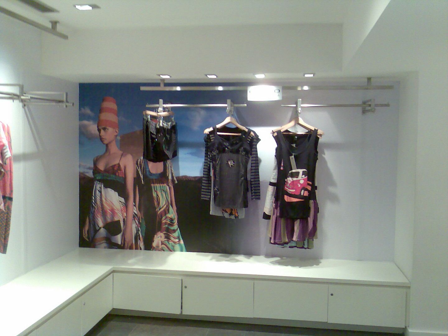 Interior of a Custo Barcelona store with campaign graphics integrated into the product display