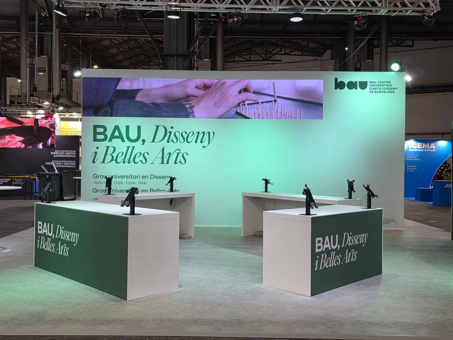 Vista frontal con mostradores y franja audiovisual. BAU, Saló de l’Ensenyament 2026, Barcelona.