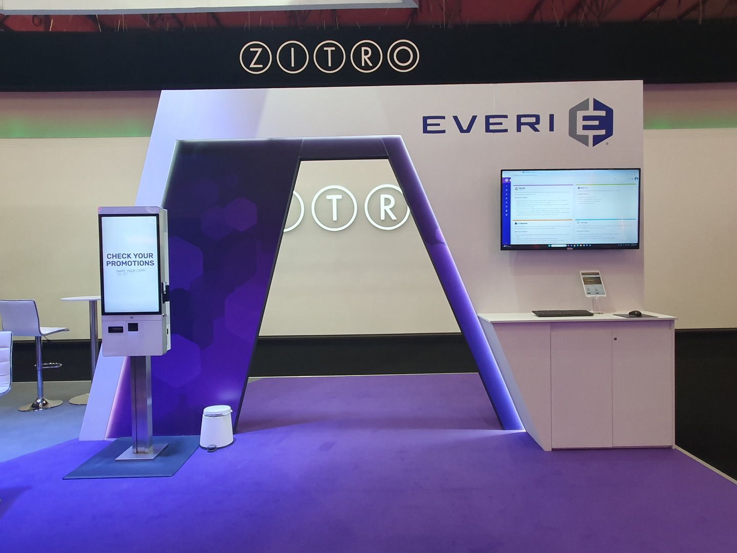 Everi purple angular frame with perimeter lighting, screen and demonstration counter