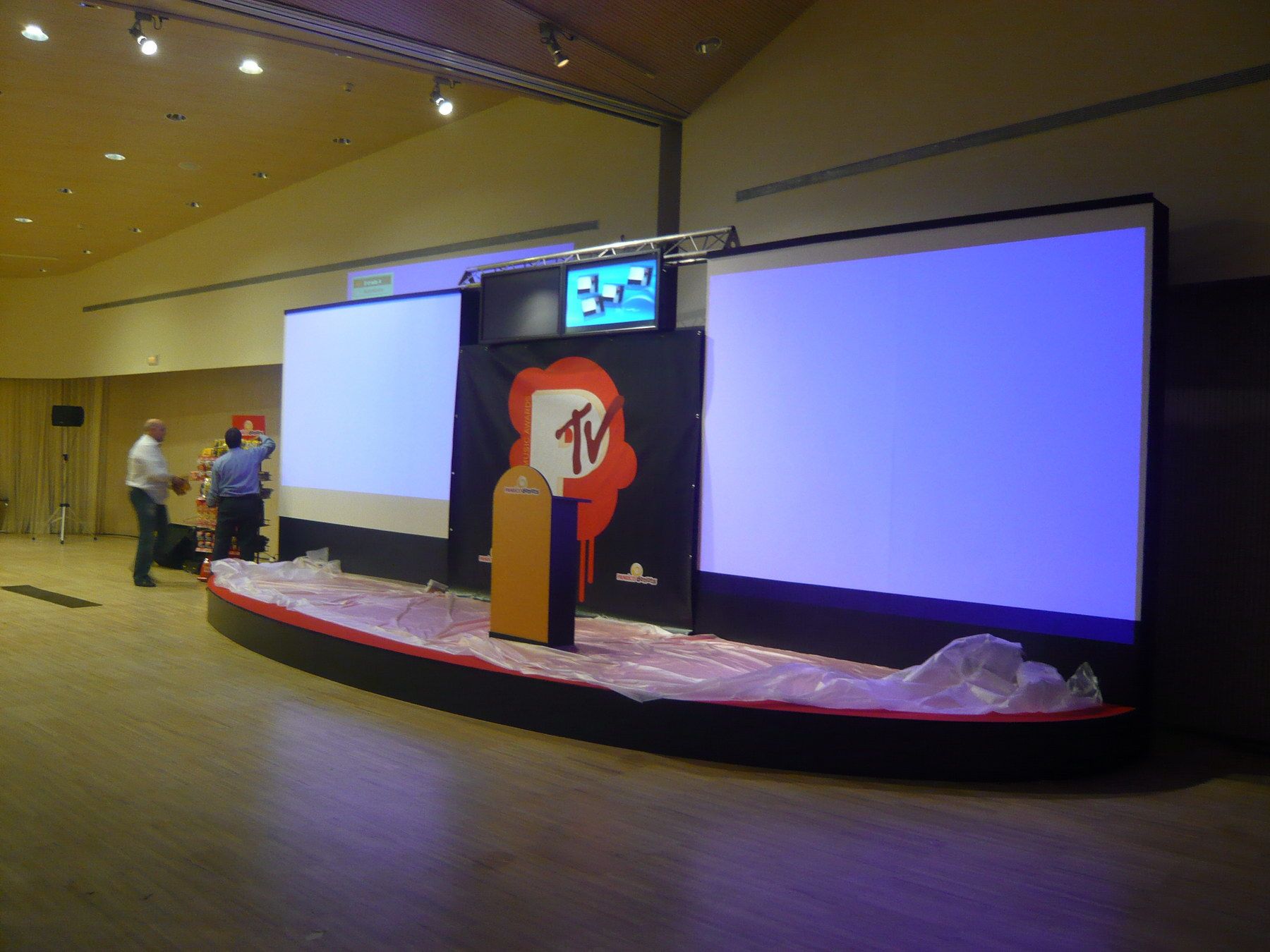 Lectern and screens on either side of the stage — Grupo Panrico