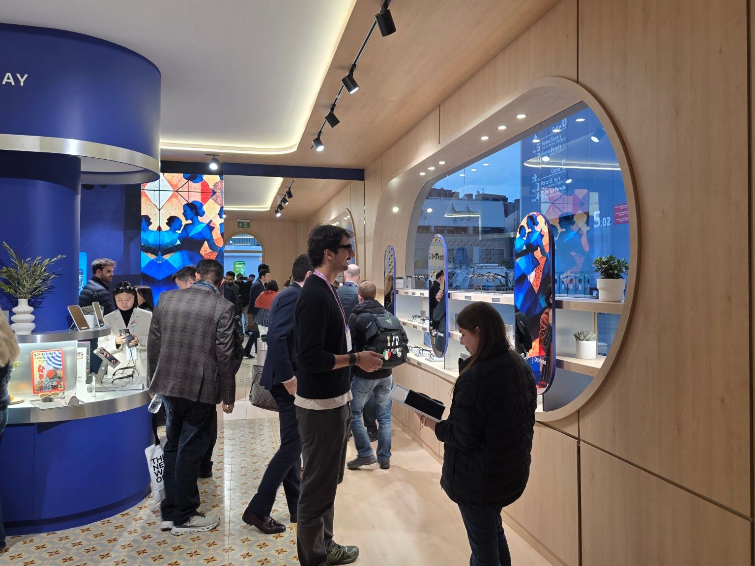 Eyewear demonstration beside the oval display window at Meta’s MWC Barcelona pavilion