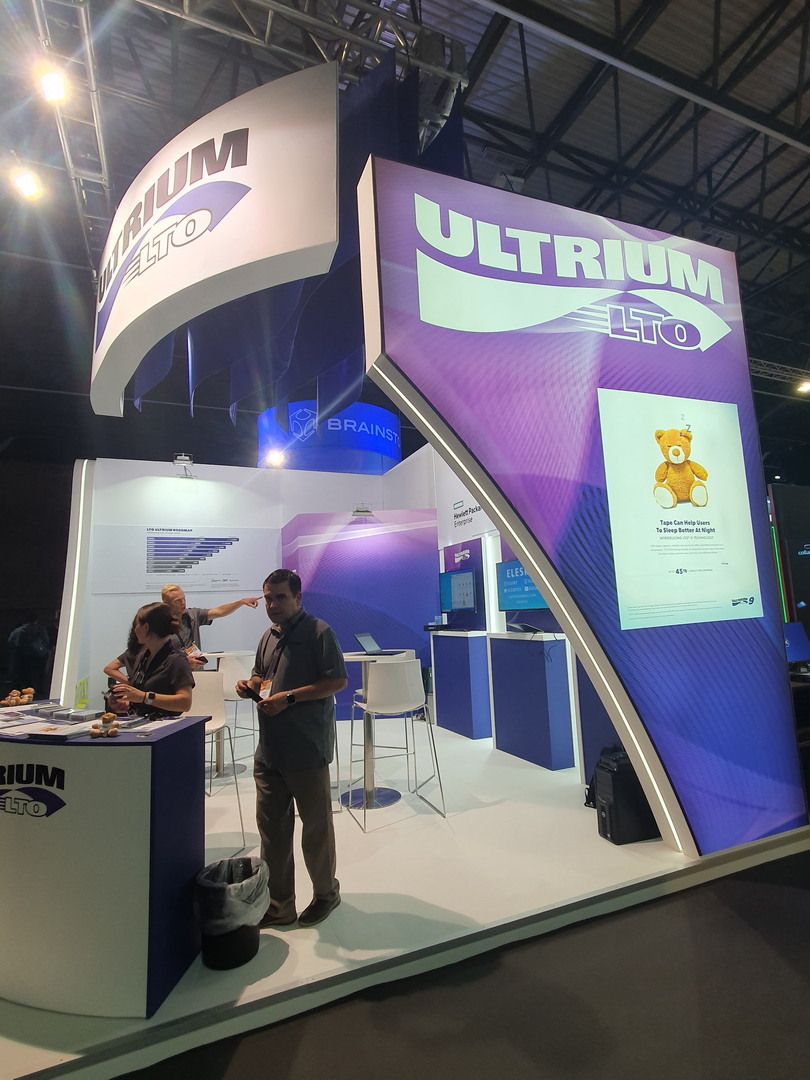 Detalle vertical del stand LTO en IBC 2022 con iluminación integrada y zona tecnológica