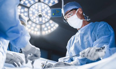 Two surgeons operating, strong light in the background