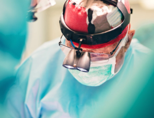 Surgeon wearing red headgear