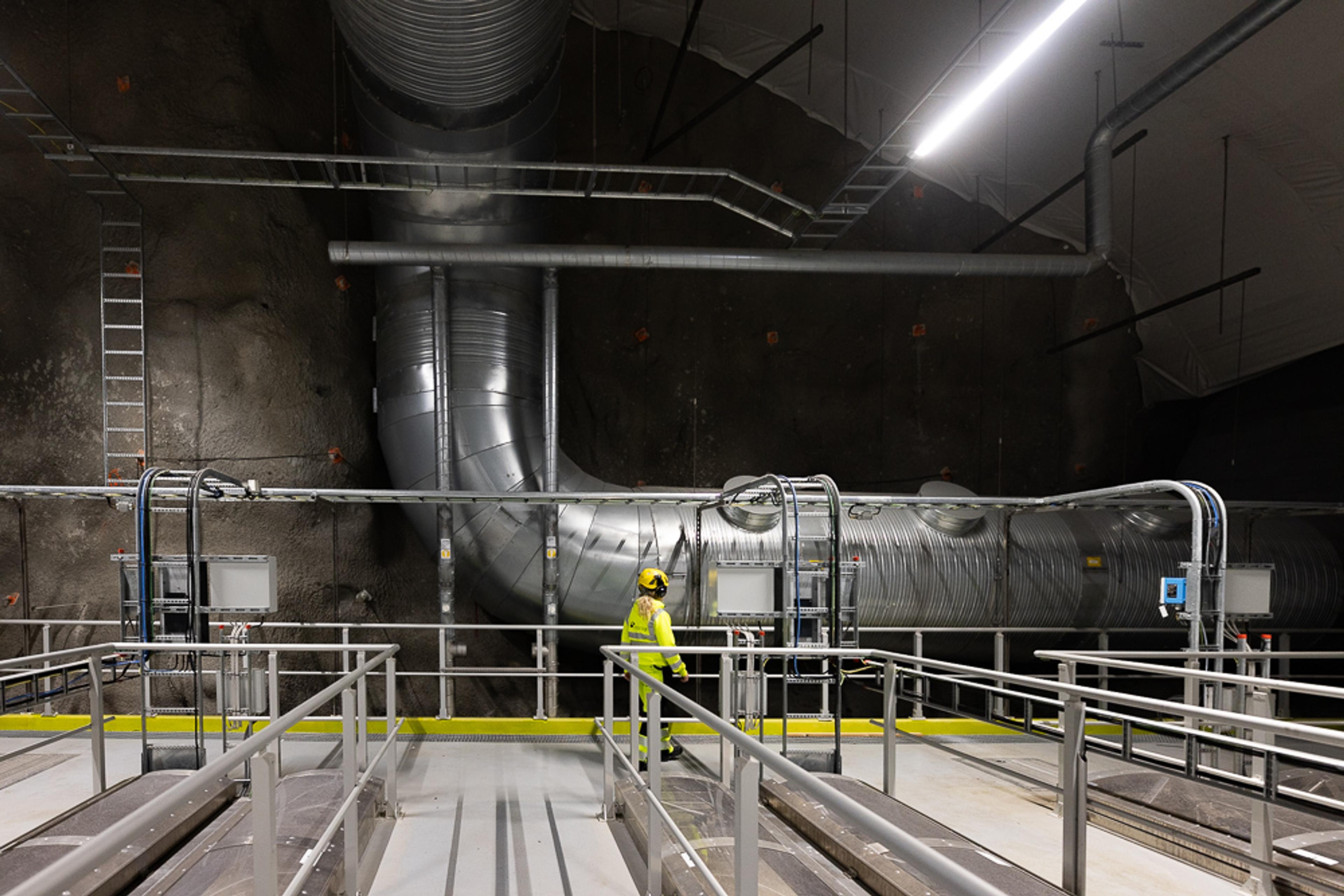 Arbeider i refleksvest inspiserer ventilasjonsanlegg i tunnel