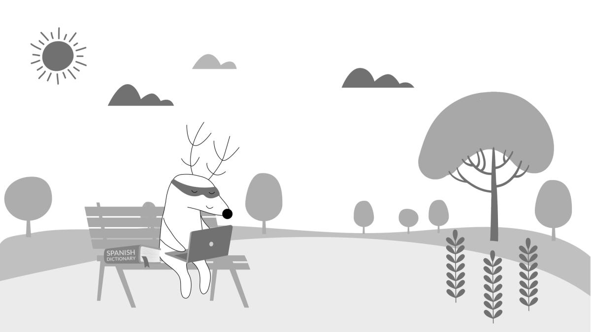 Soren is studying in a park, with a laptop and a Spanish dictionary by his side.