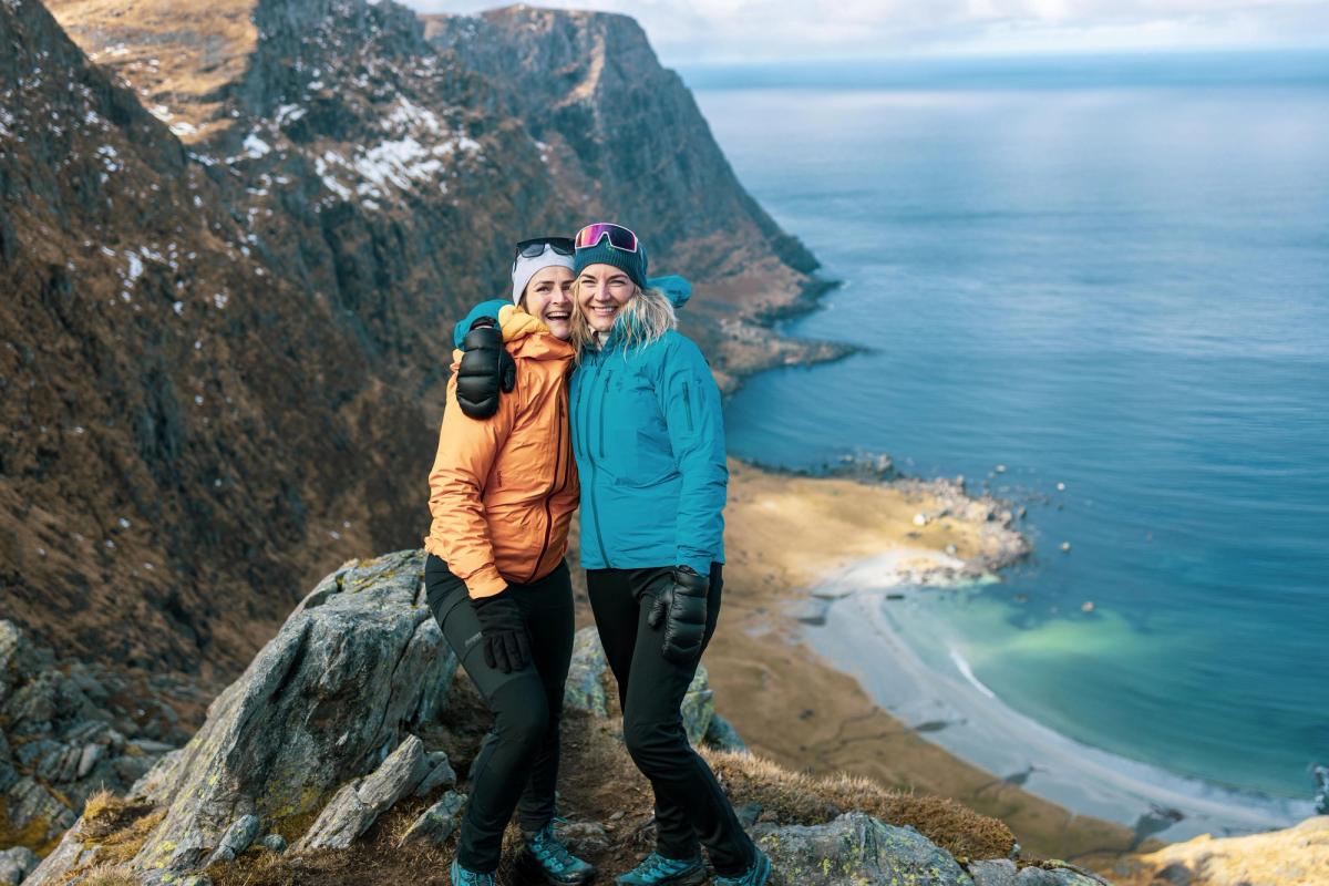 to venner som står på toppen av et fjell