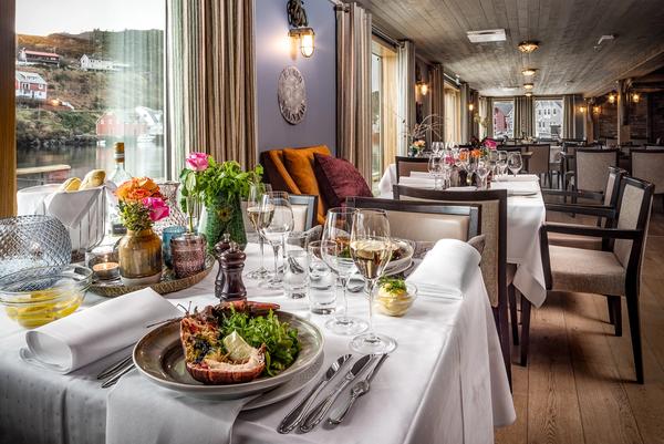 Bilde fra restauranten på Knutholmen, bord med hvite duker dekket med nydelig sjømat