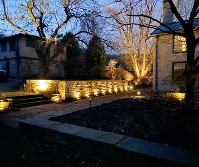 a beautifully lit sidewalk leading to the side of house