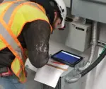 a service electrican reads a monitor