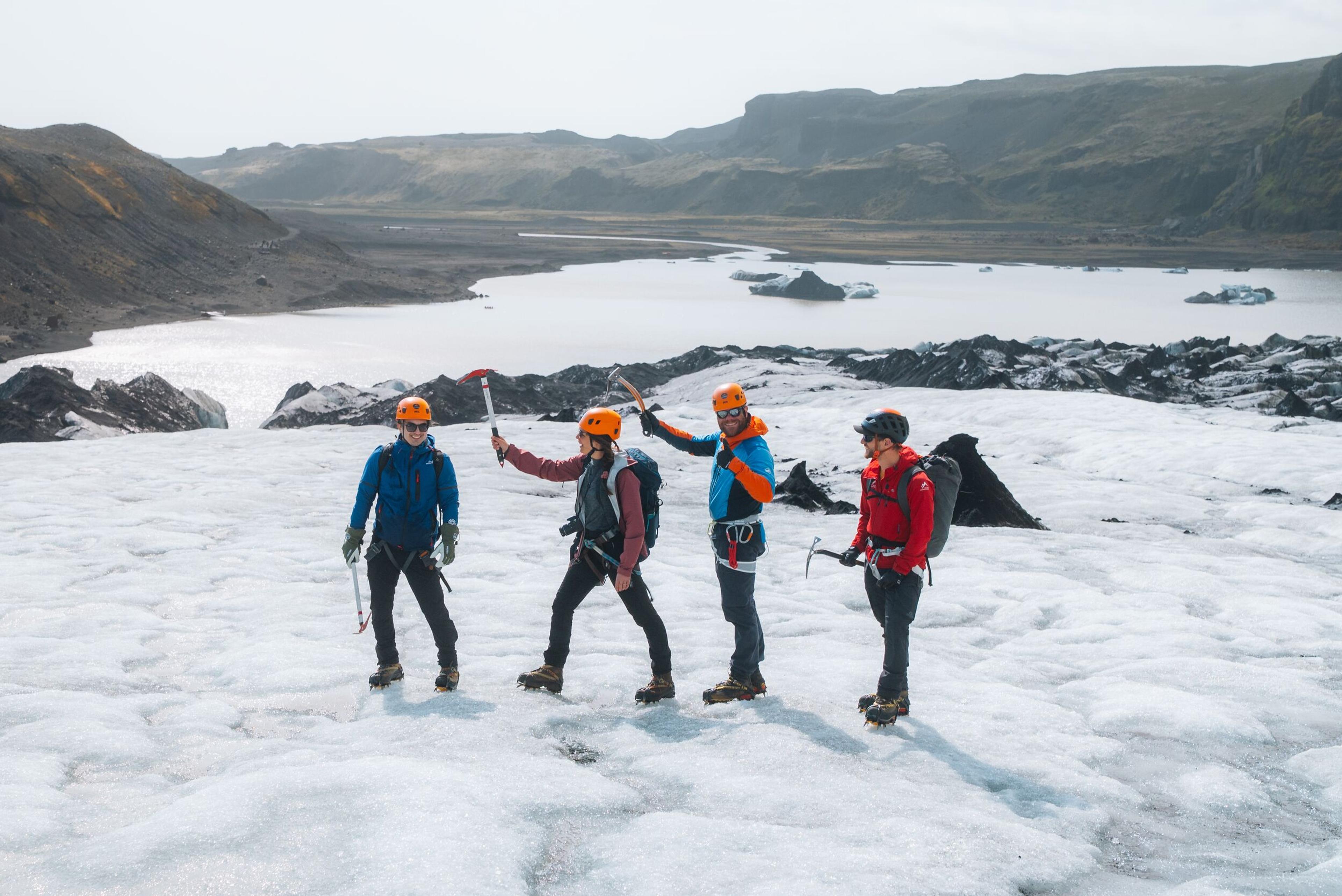 a group of people are standing on top of a glacier .