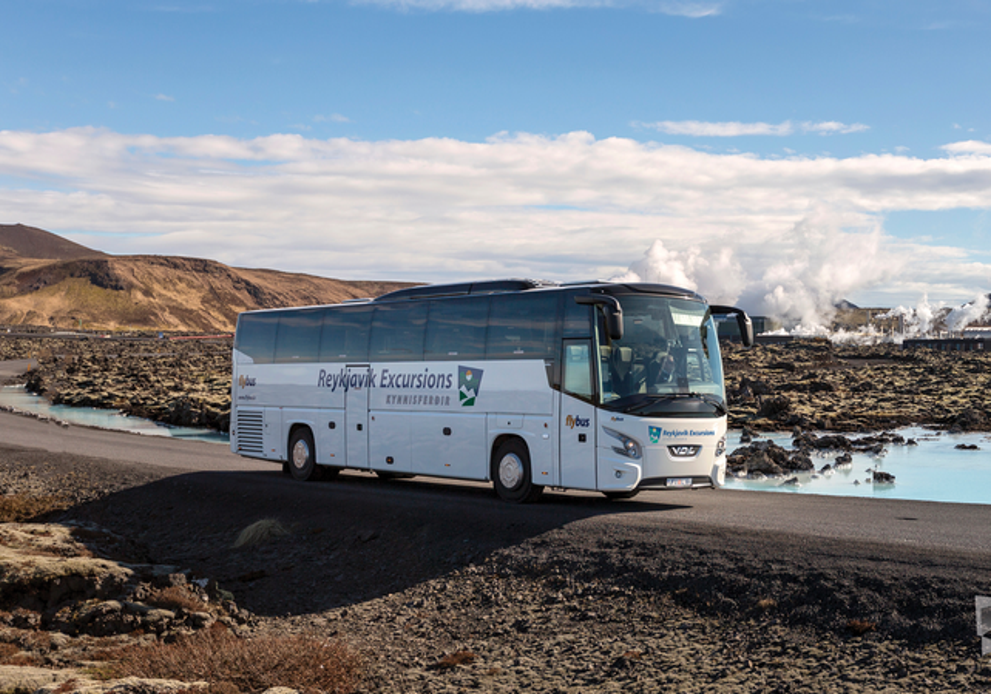 Blue lagoon transfer bus driving among a geothermal area