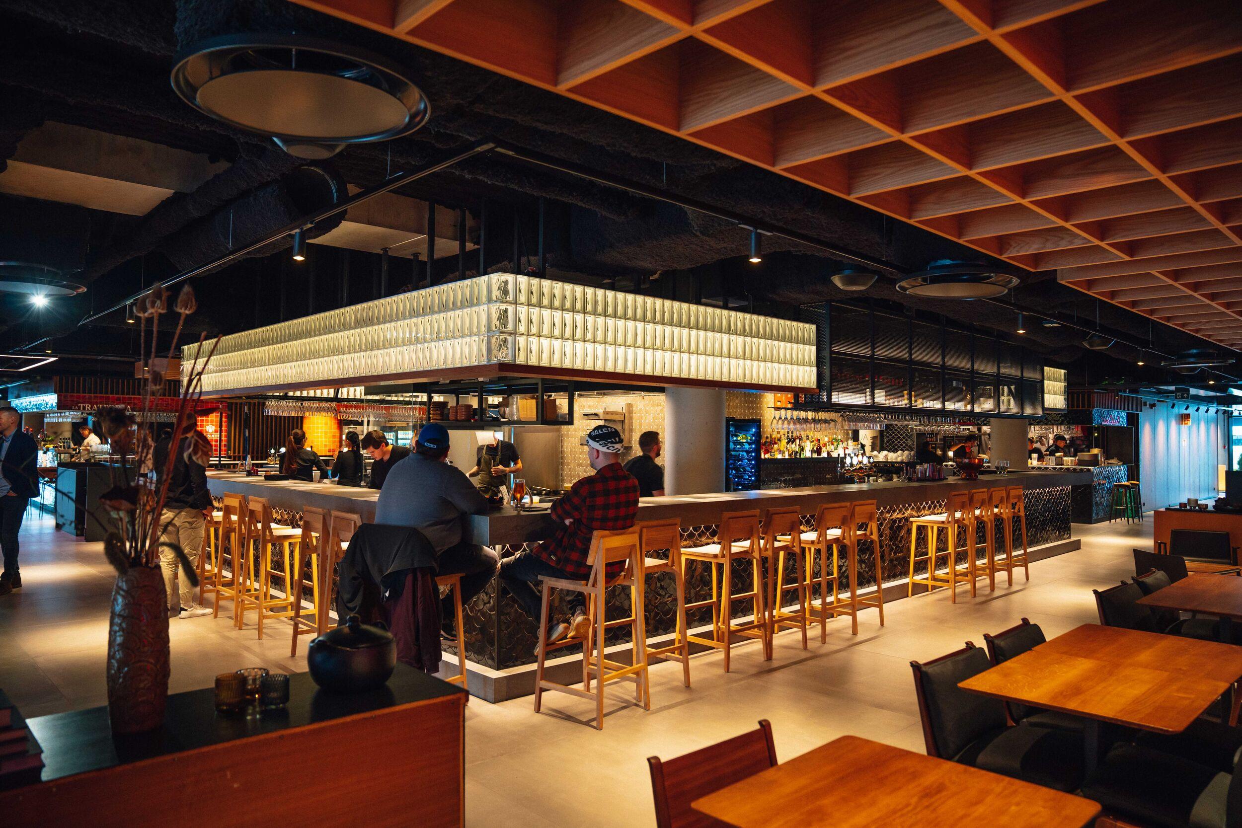 a group of people are sitting at tables in a restaurant .