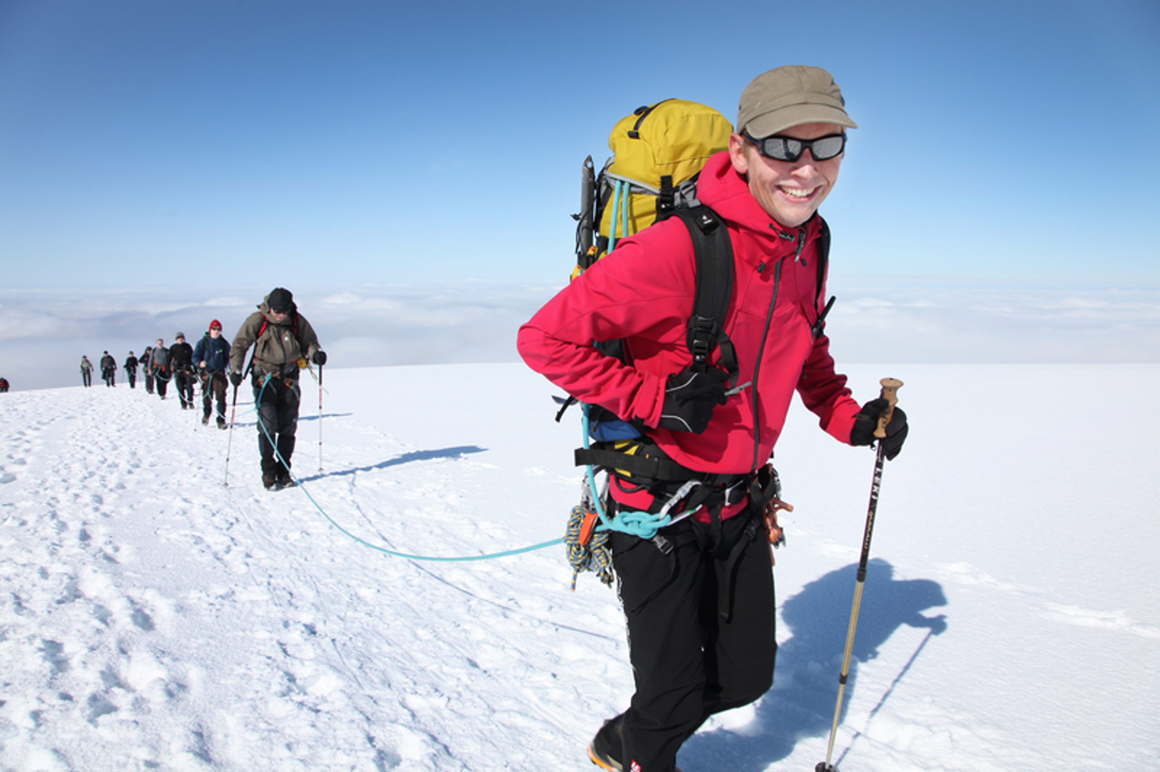 An expert guide leading a group of hikers up to the summit of Hvannadalsnjúkur Mountain in the Skaftafell area, Iceland.