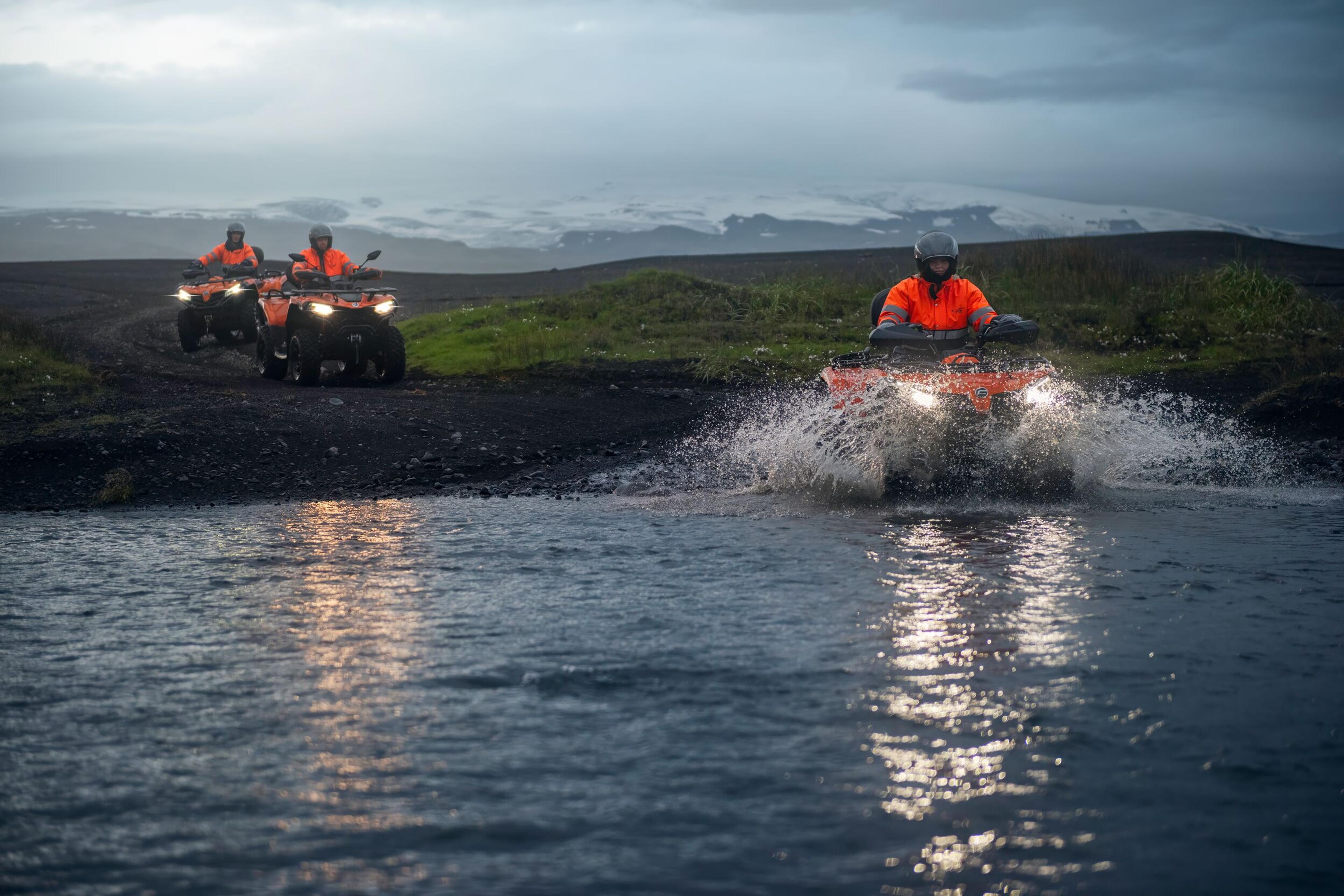 A person on a ATV looking at a plane wreck in the icelandic black beach