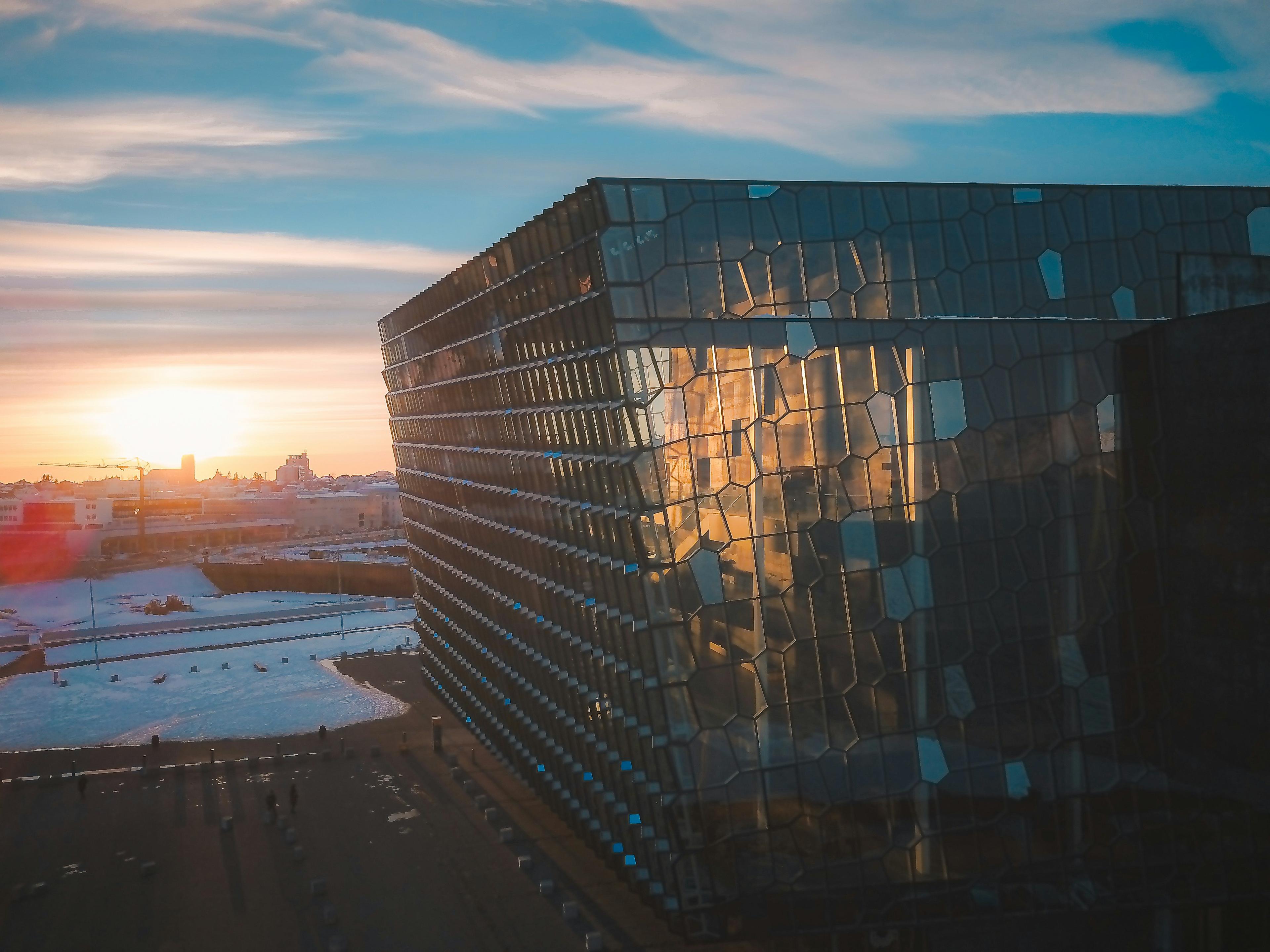 Harpa Concert Hall in Reykjavík at sunset, showcasing its geometric glass facade.