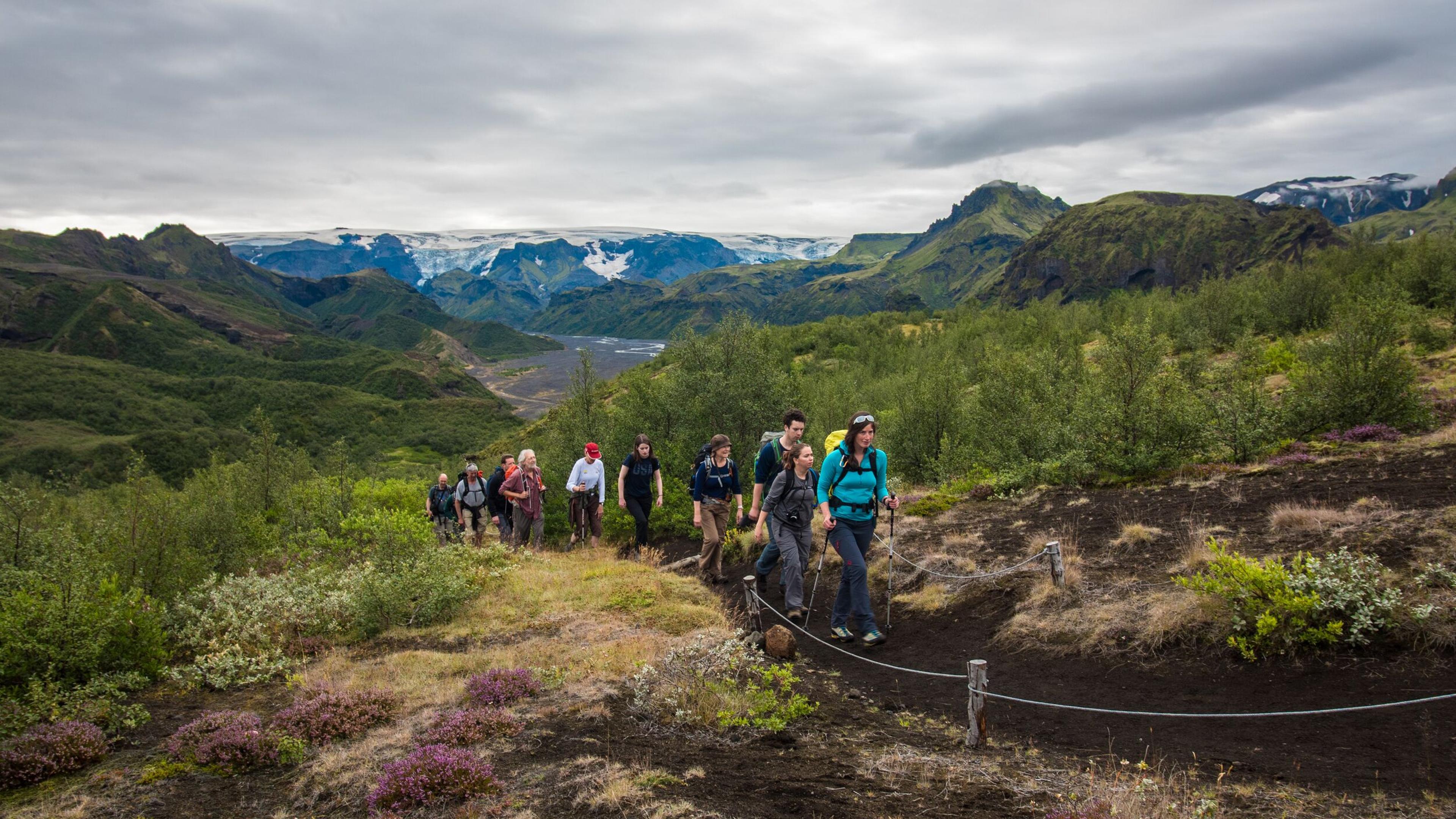 Group of people on footpath in Þórsmörk, mountains and glacier behind