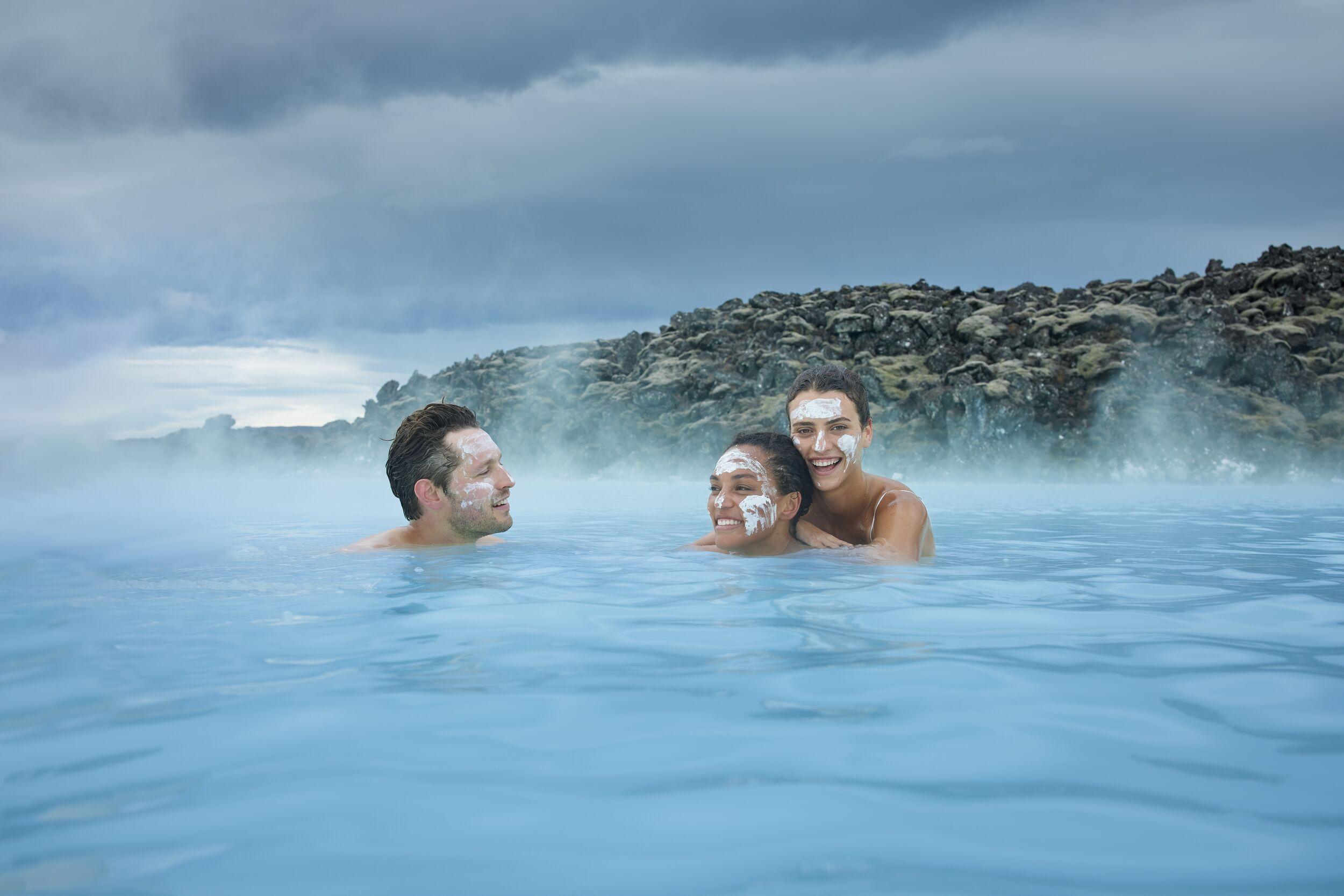 People enjoying a relaxing soak in the Blue Lagoon with silica mud masks.