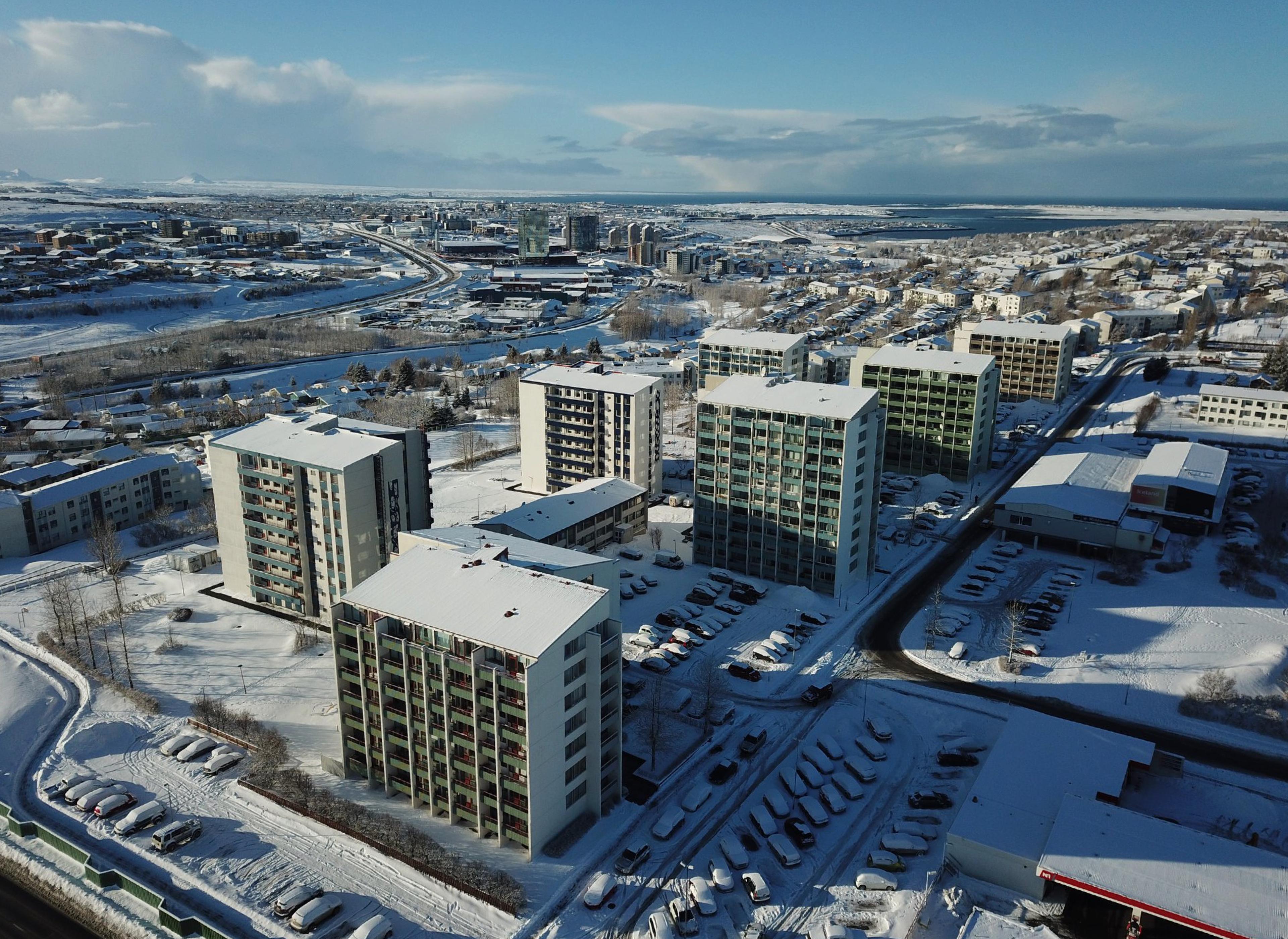 Aerial view of a residential district with tall buildings blanketed in snow during winter