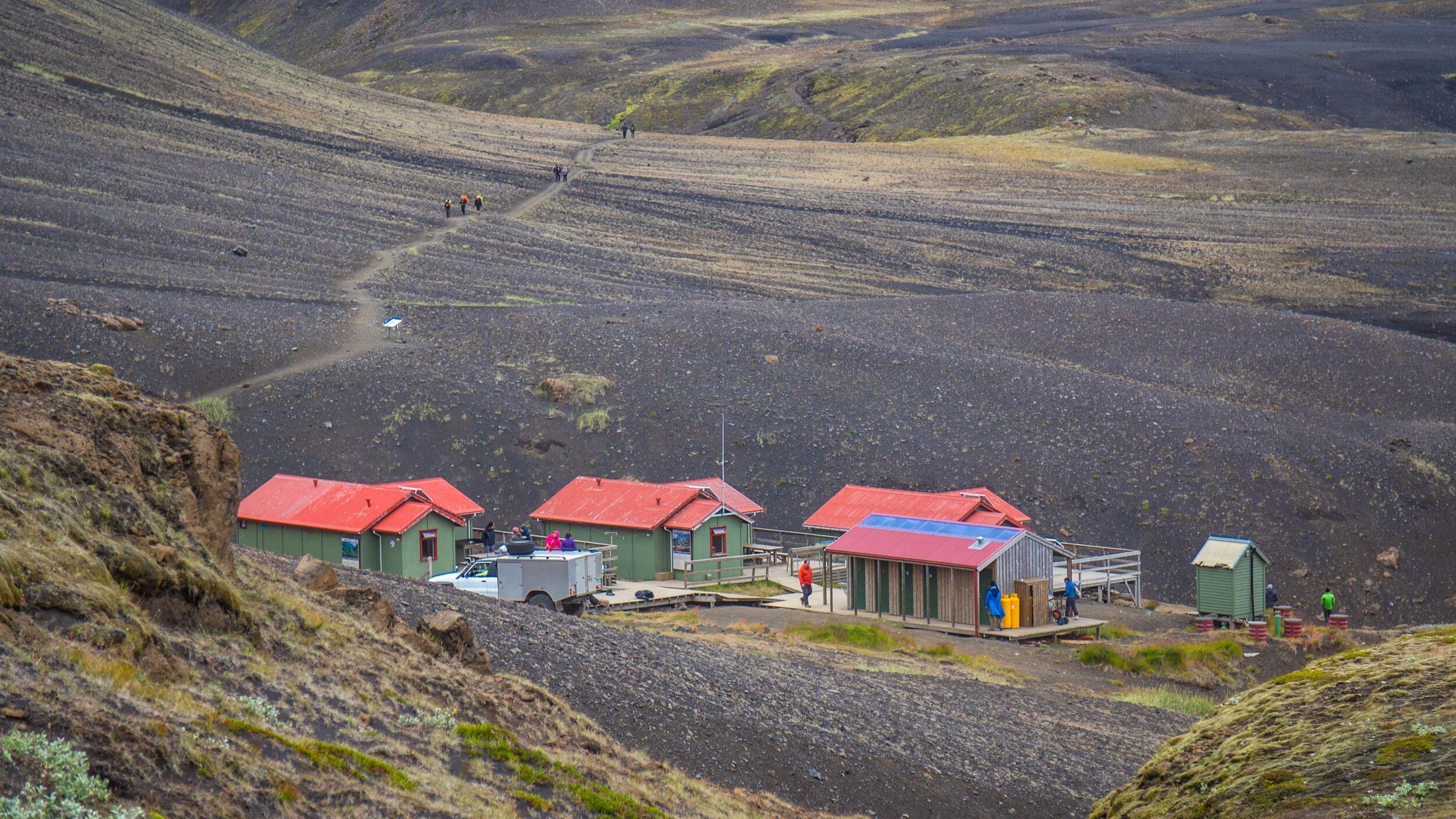 Emstrur Hut: Enjoying a Beautiful Day with Blue Skies, Red Roofs, Green Huts, and People Outside