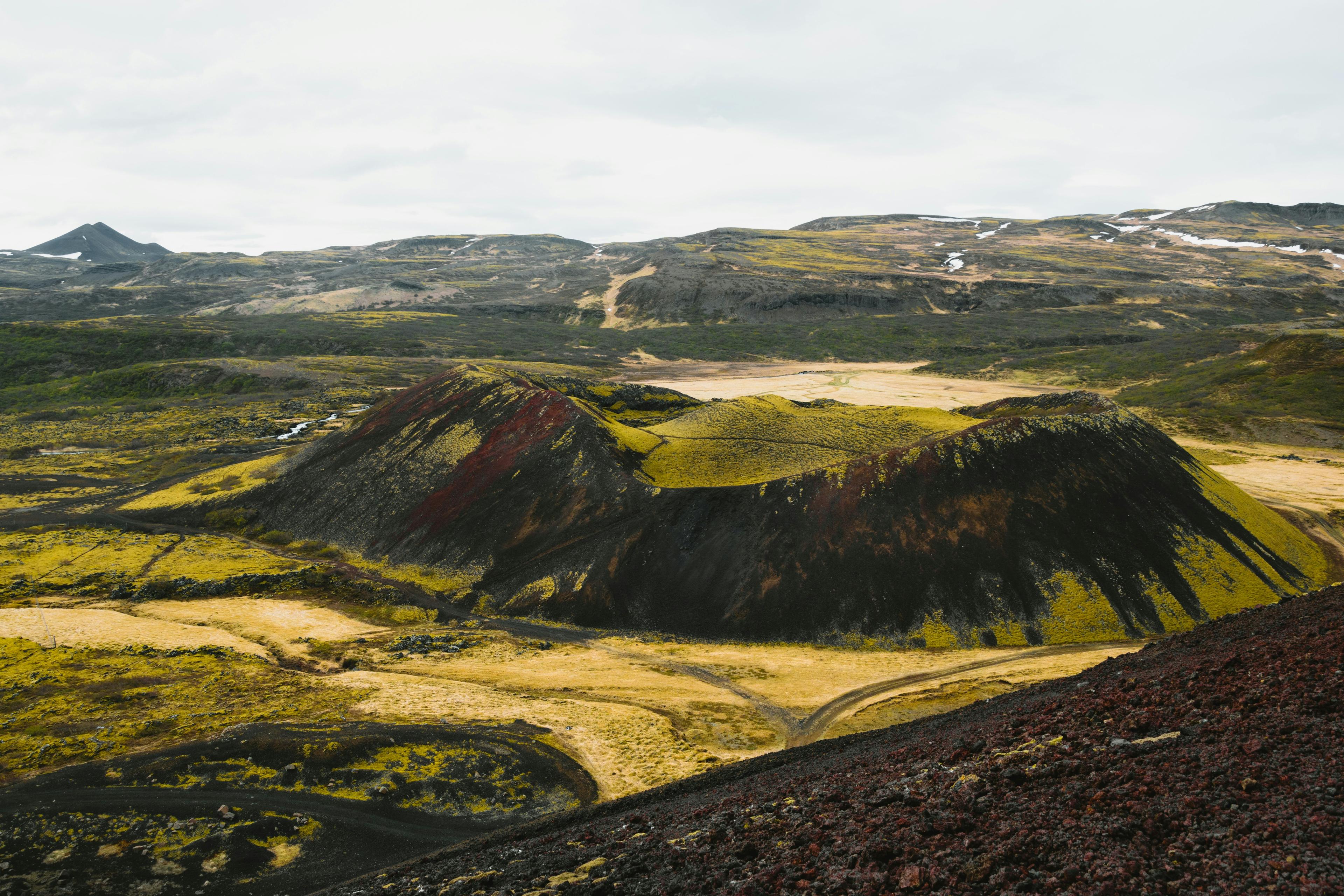 Grábrók crater with its rugged volcanic slopes covered in moss and vibrant hues, nestled in Iceland's dramatic and colorful landscapes.