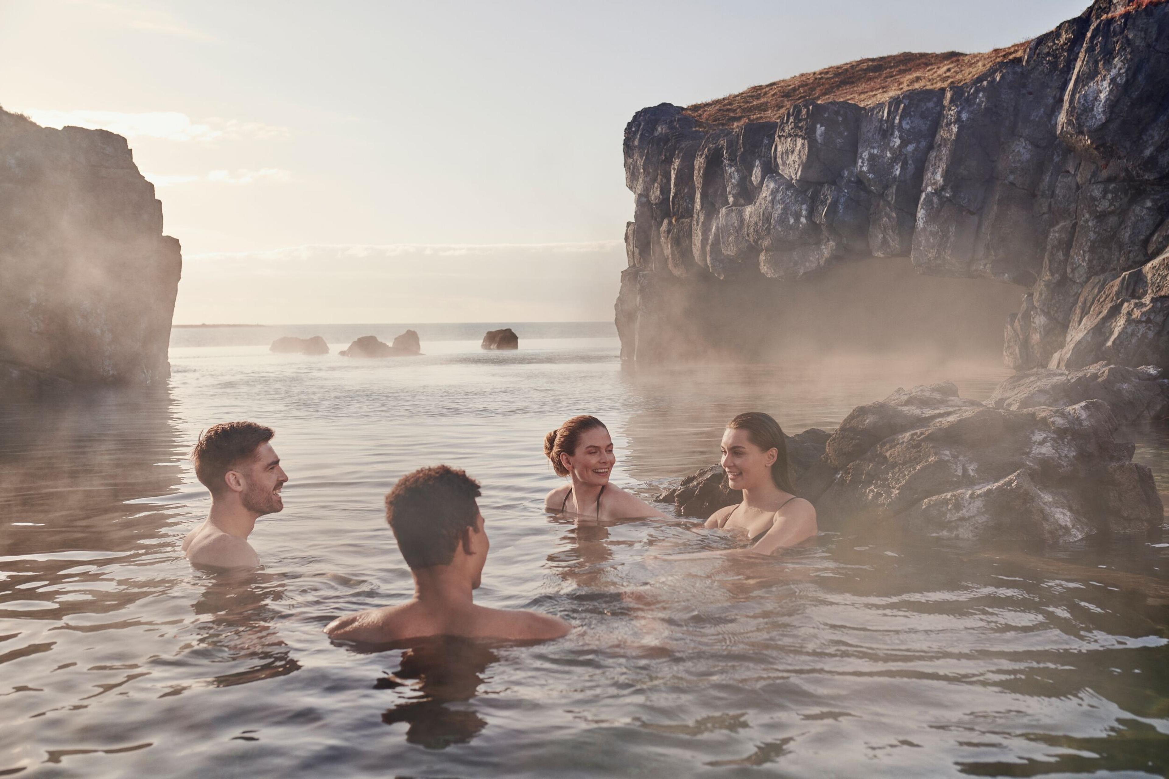 Four people relaxing at Sky Lagoon infinity pool, Iceland.