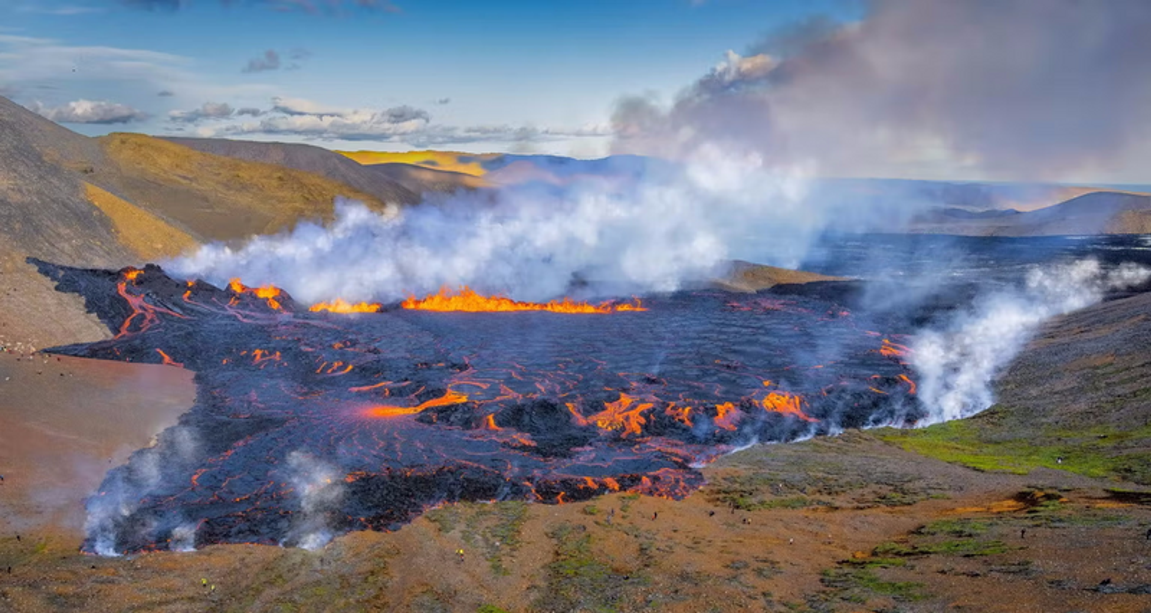 A volcanic eruption with molten lava flowing across a landscape in Iceland. 