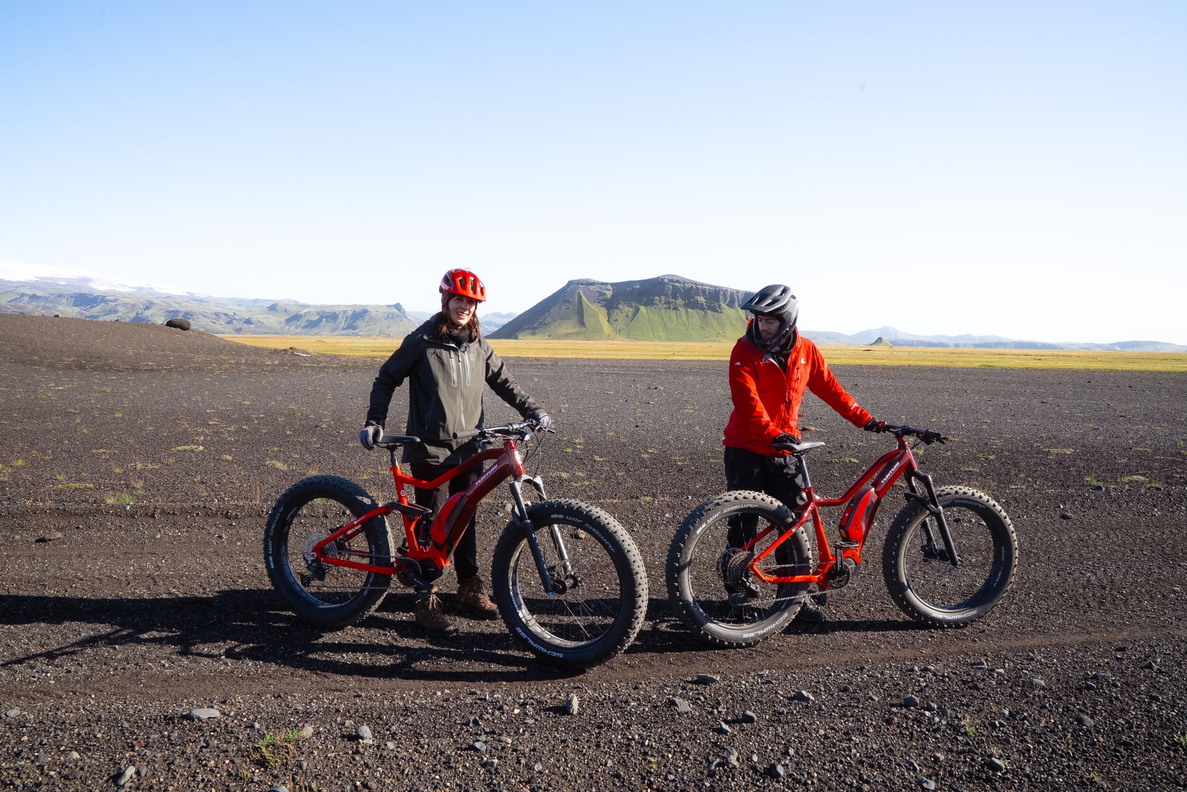 two people are standing next to each other on a dirt road .