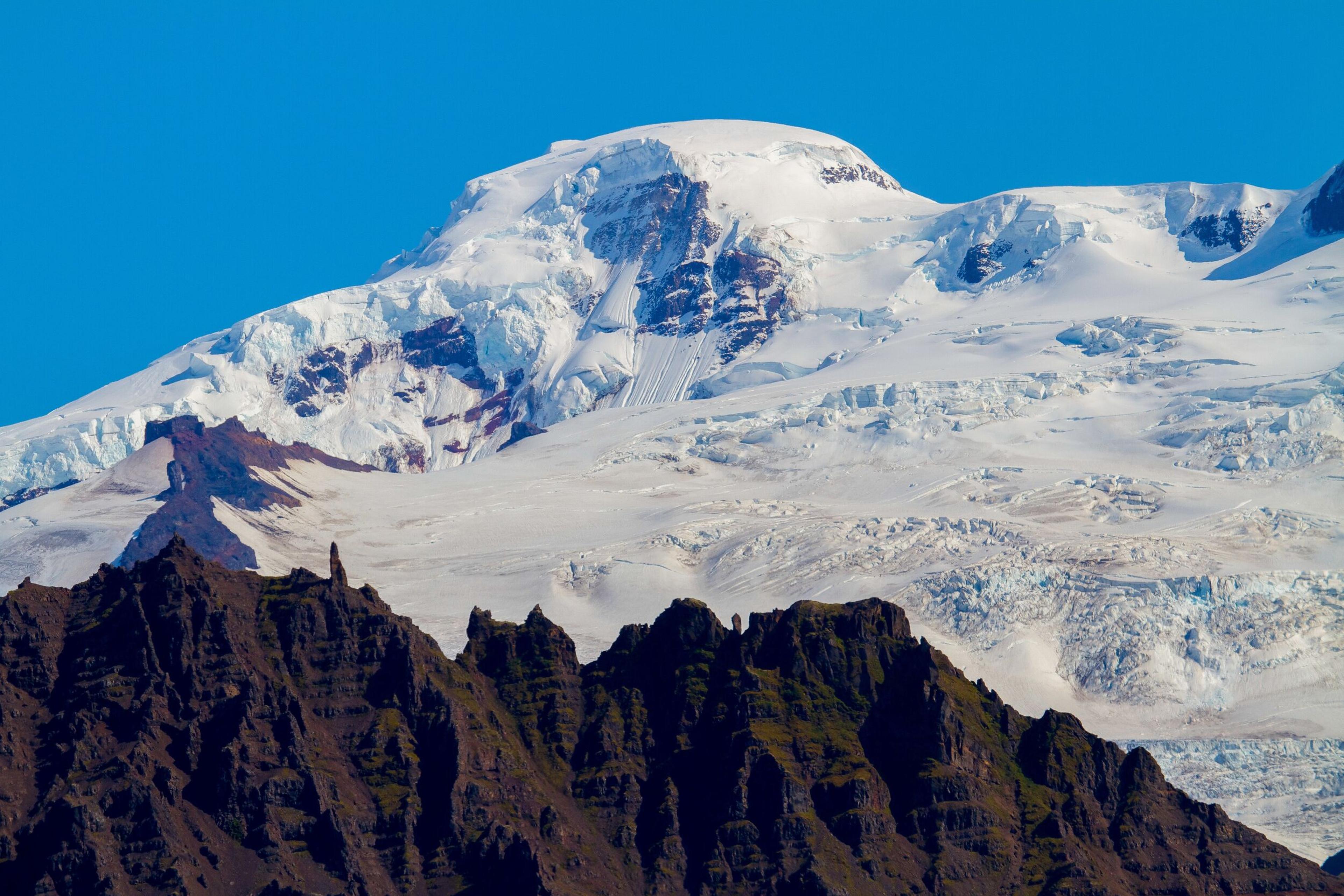 Snow-covered summit of Hvannadalsnjúkur with icy outcroppings against a clear sky