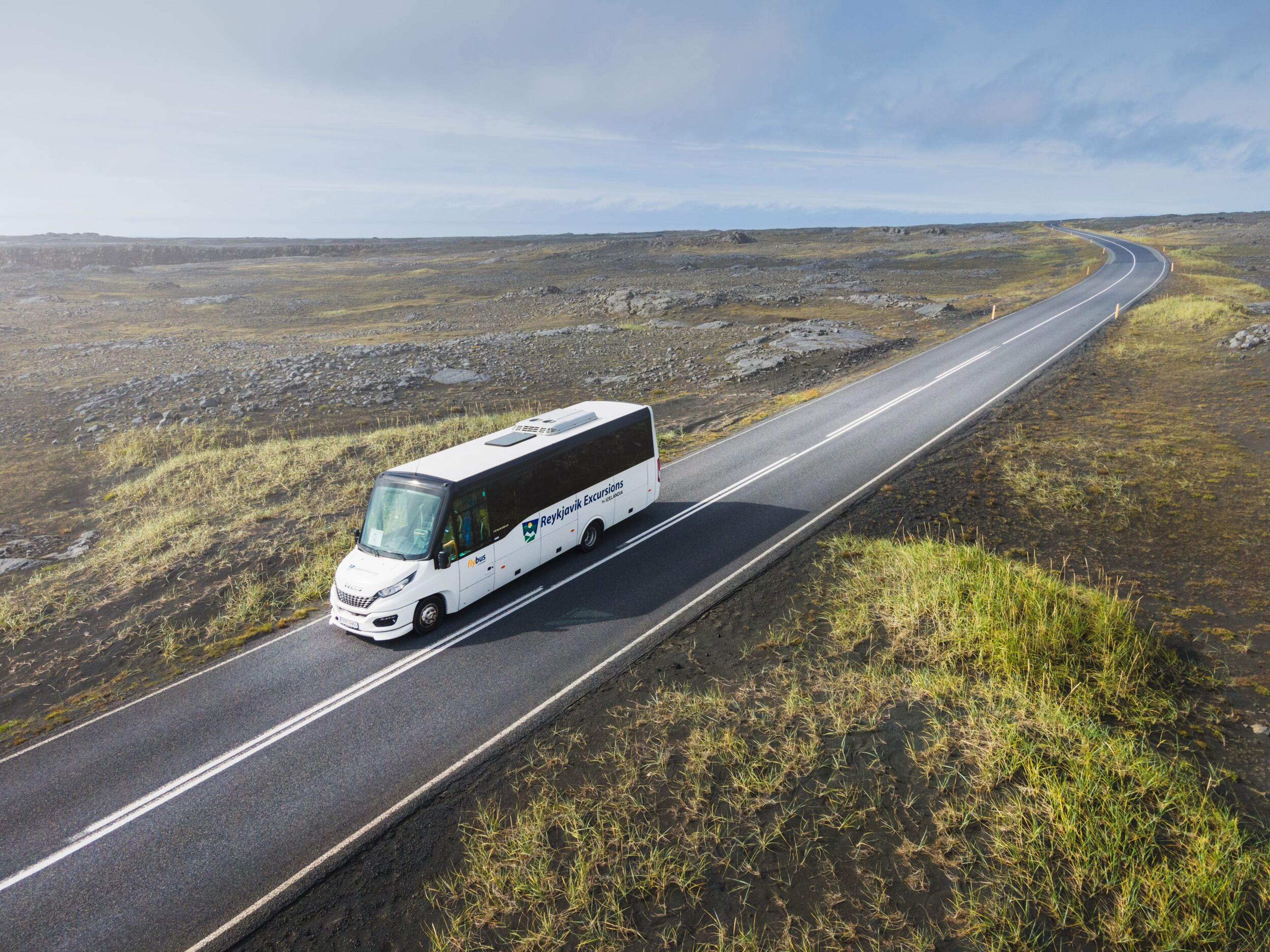 Small bus driving on an Icelandic road during summer time.