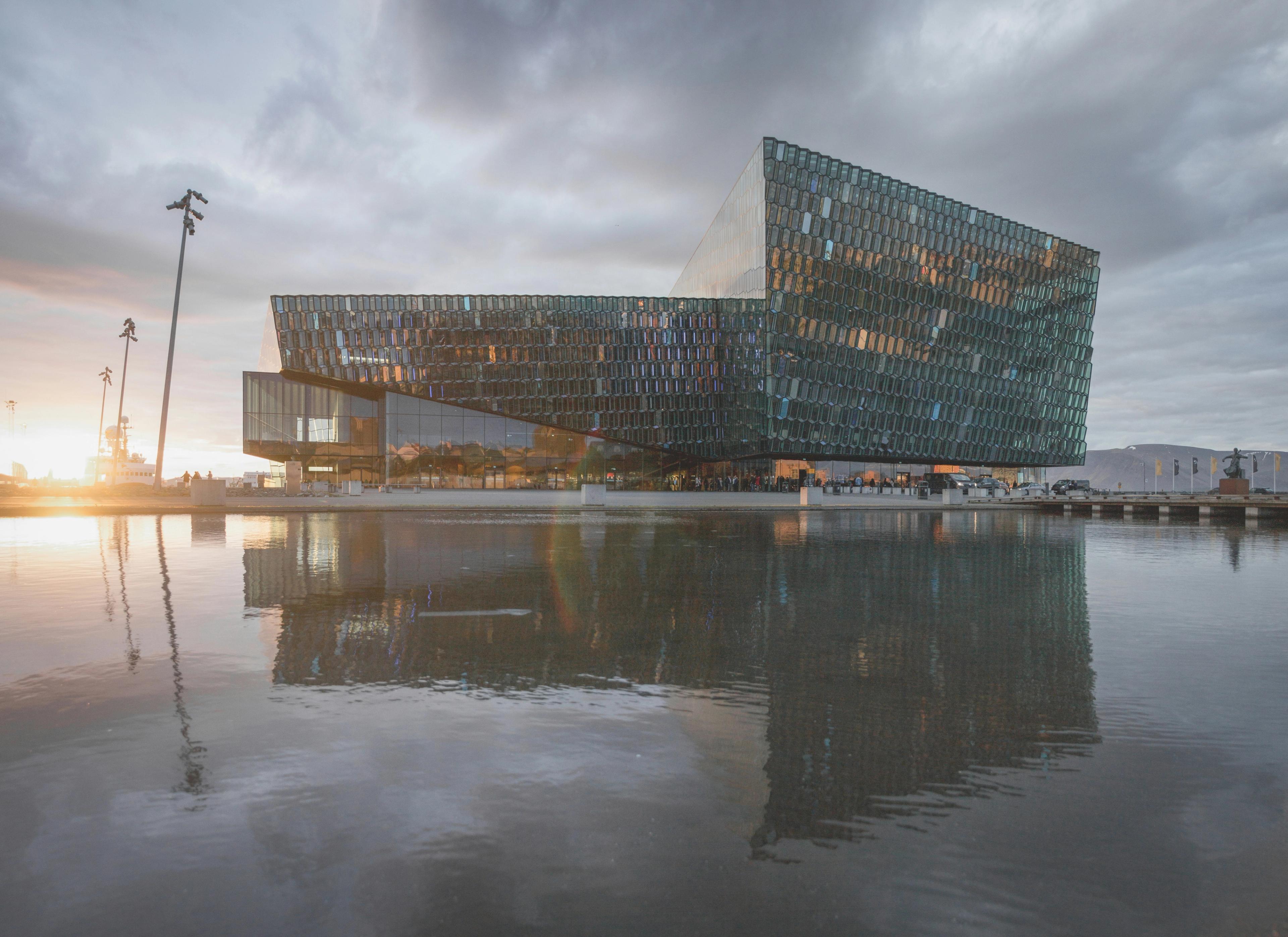 a large building is reflected in a body of water .