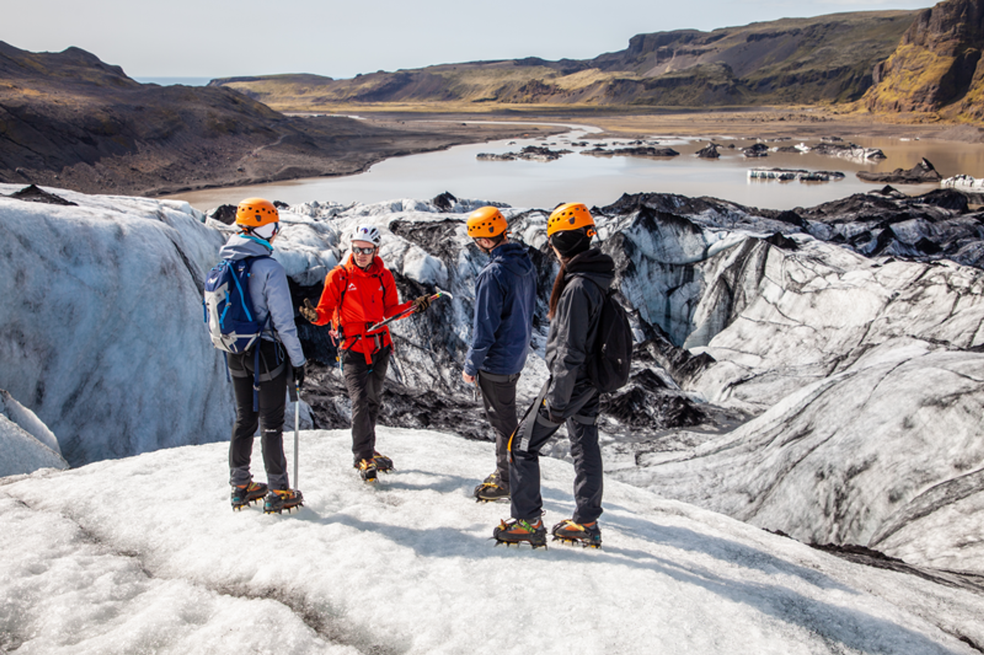 group of explorers on a glacier in Iceland. Glacial lagoon on the background.