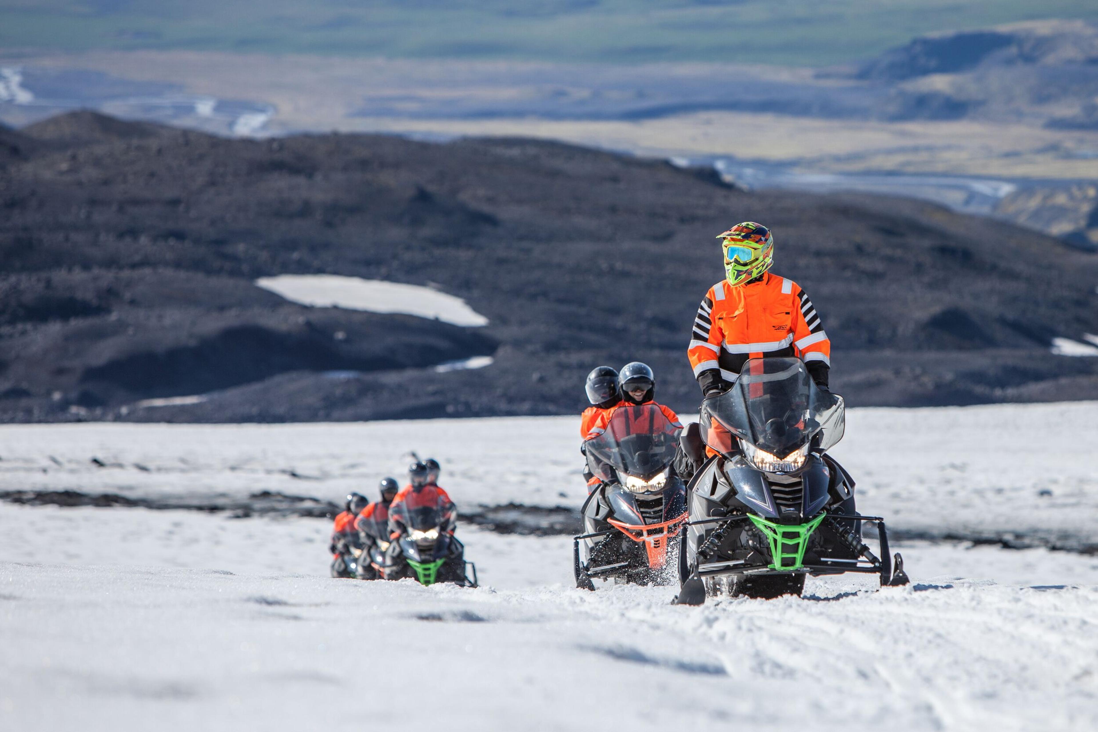Group of people riding snowmobiles on Mýrdalsjökull Glacier in Iceland