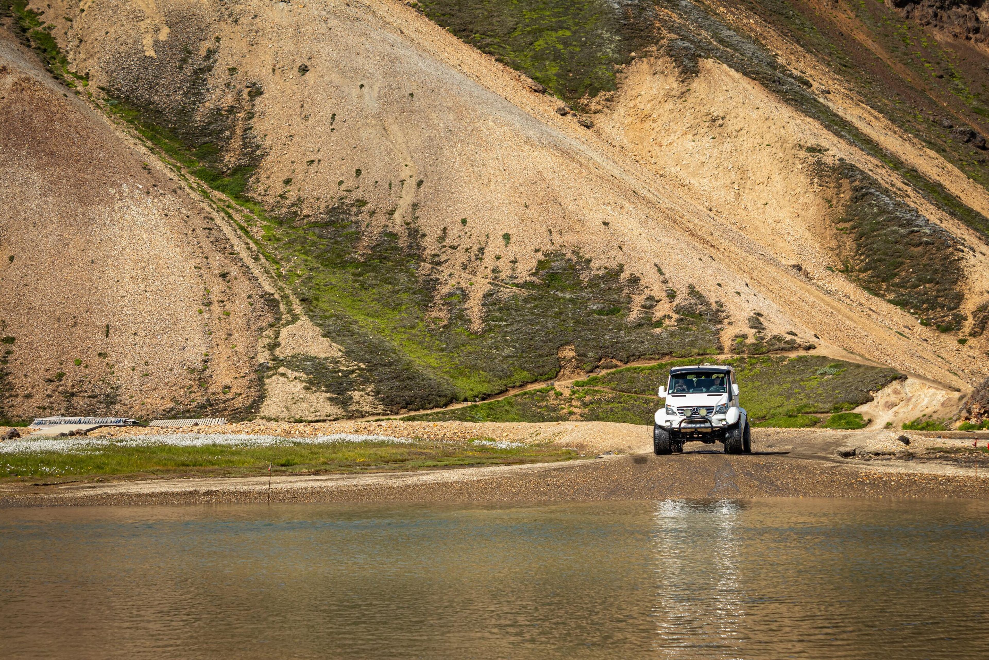 Front view of a superjeep crossing a river in the Iceland Highlands during a Landmannalaugar tour.