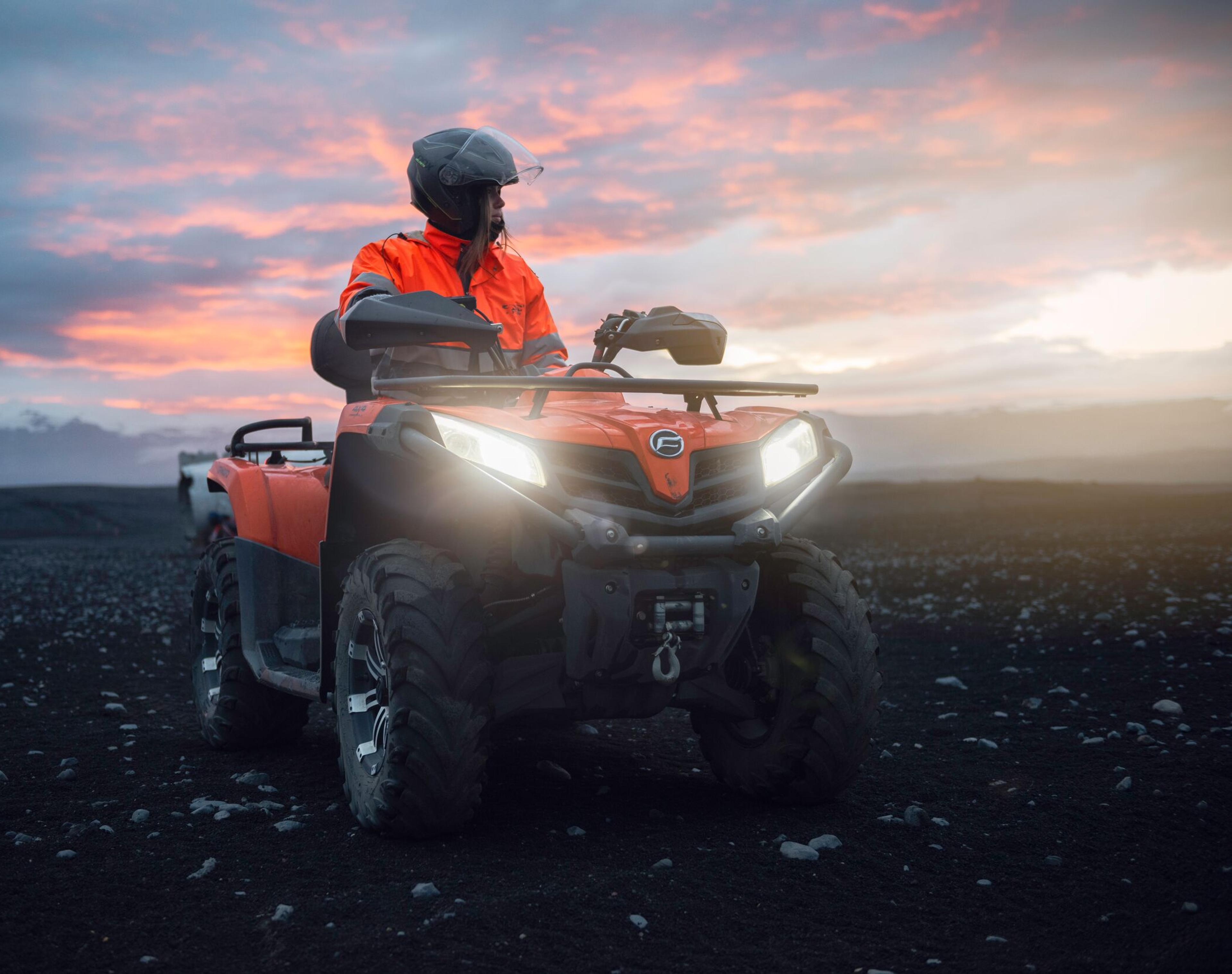 Person on an ATV on the black sand beach in Iceland.