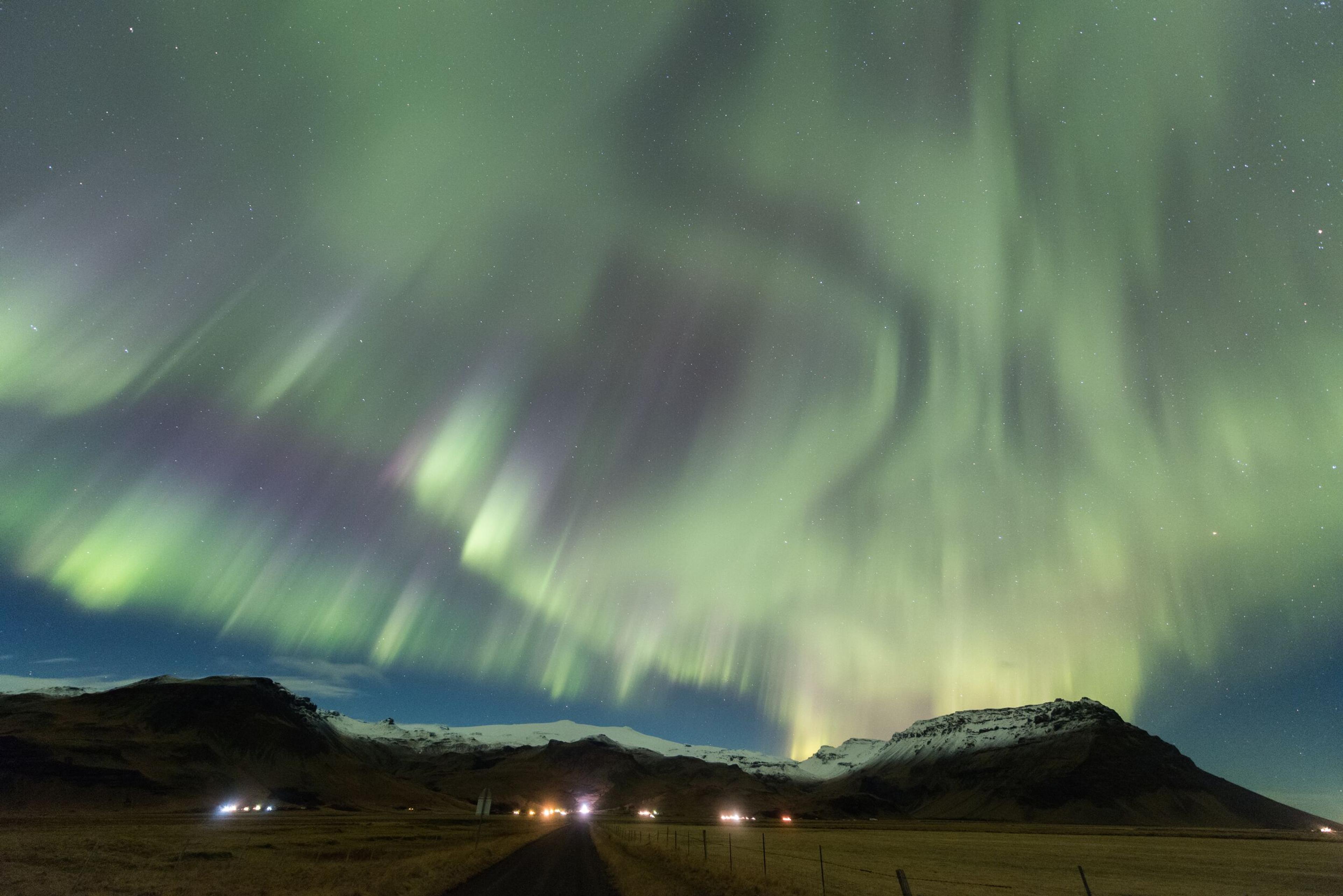  The Northern Lights illuminate the sky over Eyjafjallajökull volcano in Iceland, casting vibrant green hues above snow-covered peaks.