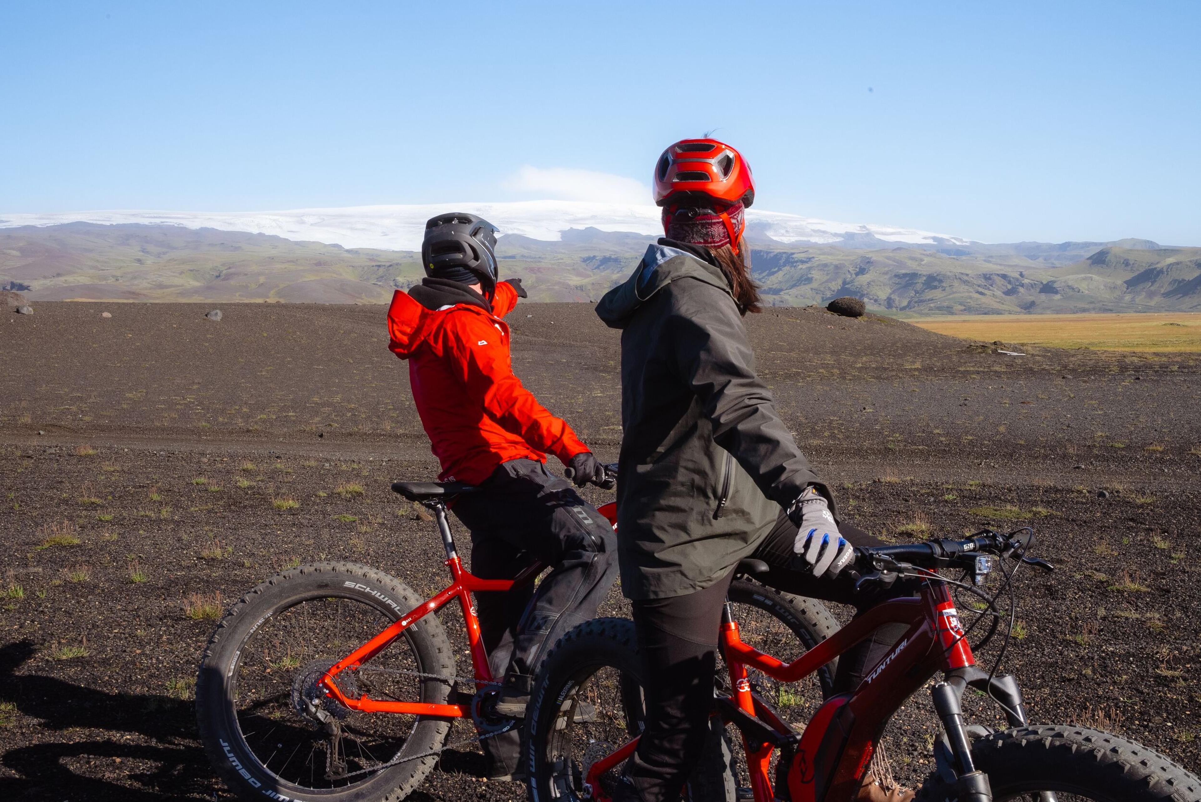 two people are riding bicycles on a dirt road .